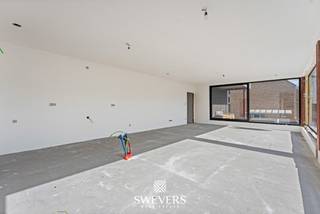 Aan de Koolmijnlaan 69 bus 1.2 in Houthalen bevindt zich dit 3-slaapkamer appartement met een bewoonbare oppervlakte van 107,65 m². Het appartement maakt deel uit van een nieuwbouwproject dat in 2026/2027 wordt opgeleverd en combineert, energiezuinigheid met een hedendaagse afwerking en een uiterst praktische indeling. Dankzij de aanwezigheid van een lift is dit een interessante keuze voor wie zorgeloos wil wonen en bovendien heb je hier alle nodige voorzieningen binnen handbereik. <br /><br />De leefruimte en keuken vormen samen één ruim en open geheel van maar liefst 44 m² en vormen het centrale hart van de woning. De open indeling creëert een aangename, lichte leefomgeving waarin koken, tafelen en ontspannen moeiteloos in elkaar overvloeien. De zithoek biedt met 20 m² alle ruimte voor een royale en gezellige inrichting, terwijl de keuken met 24 m² bijzonder ruim is opgevat. Hier is volop plaats voor een functionele én stijlvolle keukeninrichting met kookeiland en gezellige eethoek. Het resultaat is een open en uitnodigende leefruimte die perfect aansluit bij het dagelijkse gezinsleven, maar evengoed alle ruimte biedt om familie en vrienden te ontvangen.<br /><br />Een belangrijk pluspunt zijn de twee terrassen. Het eerste terras van 22m² sluit naadloos aan op de leefruimte. Het tweede terras van 15m² bevindt zich aan de achterzijde en sluit aan op de slaapkamers. Hierdoor beschikt u over veel buitenruimte, wat zeldzaam is bij appartementen van dit type. Met andere woorden, u kan hier naar eigen wens genieten van de buitenruimte op maar liefst elk moment van de dag.<br /><br />Het appartement beschikt over drie slaapkamers. De grootste slaapkamer heeft een oppervlakte van 15,75 m² en biedt voldoende ruimte voor een tweepersoonsbed en kasten. De twee andere slaapkamers meten 10,20 m² en 10 m². Deze kunnen perfect worden ingericht als kinderkamer, logeerkamer, bureau of dressing. Die flexibiliteit maakt het appartement geschikt voor verschillende levensfases.<br /><br />De badkamer is praktisch ingedeeld en sluit aan bij het hedendaagse comfort dat men van een nieuwbouwappartement verwacht. Daarnaast is er een aparte berging aanwezig. Deze ruimte is ideaal voor voorraad, poetsmateriaal, wasvoorzieningen of extra opbergmogelijkheden.<br /><br />Het gebouw is voorzien van een lift, wat het comfort verhoogt voor bewoners en bezoekers. Ook de aanwezigheid van zonnepanelen en warmtepomp is een sterk pluspunt. Ze dragen bij aan een energiezuiniger geheel en passen binnen de verwachtingen van wie vandaag bewust kiest voor een recent en toekomstgericht appartement. De kelder biedt parkeerplaatsen en bergingen aan die naar eigen wens optioneel bij aan te kopen zijn. <br /><br />De ligging aan de Koolmijnlaan in Houthalen is bijzonder functioneel. Winkels bevinden zich op ongeveer 500 meter, waardoor dagelijkse boodschappen snel geregeld zijn. Openbaar vervoer ligt op circa 180 meter en is dus vlot bereikbaar te voet. Scholen bevinden zich op ongeveer 2 kilometer, net als ontspanningsmogelijkheden en restaurants. Alles wat u vaak nodig heeft, ligt op korte afstand.<br /><br />Ook de verbinding met de ruimere omgeving is een voordeel. De snelwegen liggen op ongeveer 1,5km, waardoor verplaatsingen richting omliggende gemeenten en steden vlot verlopen. U geniet hier van de ideale centrale ligging.<br /><br />Belangrijk om te weten is bovendien dat de grondwaarde hier vastgelegd werd op €51 000. Op deze som betaal je dus slechts 12% registratierechten. Op de overige constructiewaarde van €244 000 is er 21% btw verschuldigd.<br /><br />Dit instapklare appartement aan de Koolmijnlaan 69 bus 1.2 in Houthalen biedt 107,65 m² wooncomfort, drie slaapkamers, een ruime leefruimte, een keuken met kookeiland en 2 terrassen. De nieuwbouwkwaliteit, lift, zonnepanelen, warmtepomp en gunstige ligging maken dit appartement tot een sterke keuze voor kopers die zoeken naar comfort en zorgeloos wonen. Plan een persoonlijke rondleiding en ontdek ter plaatse hoe dit appartement aansluit bij uw plannen. Voor meer informatie, bel 011 255 155. <br /><br />Prijs exclusief 21% BTW en exclusief andere belastingen en toeslagen: 295.000 euro<br />Prijs inclusief 21% BTW, exclusief andere belastingen en toeslagen: 346.240 euro