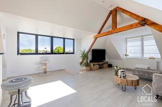 In het landelijke Zarlardinge bevindt zich dit verrassend ruime en instapklare duplexappartement met aparte privatieve ingang. De woonst combineert een praktische indeling met veel lichtinval en een warme, karaktervolle uitstraling dankzij de zichtbare houten dakstructuur. Via de afzonderlijke inkomhal kom je binnen in het appartement, waarna de trap je naar de nachthal brengt. Het appartement biedt een verzorgde badkamer met ligbad, inloopdouche en dubbele lavabo, een toilet en een praktische wasruimte. De verschillende kamers kunnen flexibel worden ingericht als slaapkamer, dressing, bureau of hobbyruimte, waardoor de woning zich perfect aanpast aan verschillende woonbehoeften.<br />Op de hoogste verdieping kan u de leefruimte terugvinden. Deze vormt het hart van de woning en biedt plaats voor een gezellige zithoek, een eetgedeelte en een volledig ingerichte open keuken. De grote ramen en dakvensters zorgen voor een aangenaam open gevoel, terwijl de authentieke houten balken extra charme toevoegen.<br />De keuken is ruim opgevat en beschikt over veel werk- en opbergruimte. Dankzij de neutrale afwerking, lichte vloeren en goed onderhouden staat is dit appartement volledig instapklaar. Een ideale woonst voor wie op zoek is naar ruimte, comfort en karakter op een centrale locatie, met het bijkomende voordeel van een volledig aparte ingang.<br />Kom jij graag deze eigendom bezoeken? Mail dan naar info@localsvastgoed.be of bel naar 054 23 53 83.