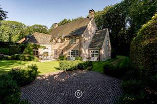 Deze landelijke villa, ontworpen door architect Bart François op een perfect georiënteerd perceel van 2730 m² heeft 4 slaapkamers, 2 badkamers en een grote garage voor 2 wagens.<br /><br />De woning is minutieus onderhouden, perfect instapklaar en biedt tal van mogelijkheden door de grote gezellige ruimtes, het prachtige uitzicht op de mooie tuin en de stijlvolle inrichting met warme materialen. Dit alles optimaal gelegen in een mooie dreef van Sint-Martens-Latem op 900 meter van de golf.<br /><br />Je komt de villa binnen via de inkomhal met trap, vestiaire en gastentoilet. De hal geeft toegang naar de gezellige zitplaats met open haard, die dan voorts een doorgang geeft naar de cosy tv-hoek. De eetruimte leidt naar een grote uiterst lichtrijke leefkeuken die voorzien is van alle toestellen. Al deze ruimtes staan mooi in contact met de tuin. In aansluiting met de keuken vind je een bijkeuken met wasplaats/berging en een ruime koelcel. Kers op de taart is de grote ingerichte en gekoelde wijnkelder op -1. Op het gelijkvloers voorts nog een gezellige en lichtrijke bureau en een inpandige garage voor 2 wagens met aansluitend berging en technische ruimte.<br /><br />Boven leidt de nachthal enerzijds naar het mastergedeelte met slaapkamer, grote dressing en badkamer (dubbele lavabo, bad, douche en toilet). Voorts op de verdieping het kinder- of gastengedeelte met 3 slaapkamers (waarvan één met grote dressing), apart toilet en badkamer met ligbad, hammam en wastafel. <br /><br />De tweede verdieping kan perfect ingericht worden als een verblijf voor de au-pair of kan omgevormd worden naar 2 extra slaapkamers.