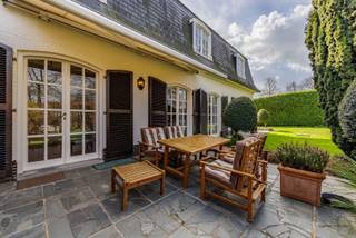 Deze karaktervolle Franse villa straalt charme en klasse uit vanaf het eerste moment. Via de statige inkomhal betreedt u de woning, waar authenticiteit en ruimtegevoel meteen samenkomen. De ruime, lichtrijke leefruimte met prachtig parket vormt het hart van de woning en biedt een warme en uitnodigende sfeer.<br /><br />Aansluitend vindt u een afzonderlijke keuken met aanpalend een handige berging. Daarnaast beschikt de woning over een bijkeuken en sanitaire cel, en een gastentoilet wat extra comfort en functionaliteit biedt. Een afzonderlijk bureel maakt thuiswerken in alle rust perfect mogelijk.<br /><br />Op de verdieping bevindt zich een ruime nachthal die toegang geeft tot vier volwaardige, ruime slaapkamers. De verdieping wordt vervolledigd met een grote badkamer en een afzonderlijk toilet.<br /><br />Verder beschikt de woning over een ruime kelder met voorraadmogelijkheden en een dubbele garage, wat zorgt voor extra bergruimte en praktisch gemak.<br /><br />Buiten geniet u van een aangename tuin waar het heerlijk tot rust komen is. Het terras is uitgerust met een zonneluifel, ideaal om ook op warme dagen comfortabel buiten te vertoeven. Bovendien is er de mogelijkheid om het achtergelegen perceel van circa 1680 m² (zwart gearceerd op de laatste luchtfoto) optioneel bij aan te kopen; de arcering is louter indicatief en biedt geen enkele waarborg omtrent de exacte oppervlakte of afmetingen.<br /><br />Kortom: een prachtige, karaktervolle villa waar rust, ruimte en charme hand in hand gaan.