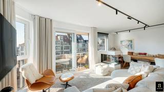 Cet appartement d'angle aménagé avec goût bénéficie d'une orientation sud sur la Graaf d'Ursellaan, récemment réaménagée, avec une vue dégagée sur la verdure et à deux pas de la plage. La Graaf d'Ursellaan est l'une des plus belles avenues de Heist, avec de jolies boutiques, des restaurants et à proximité de la célèbre Heldentoren. <br />En 2021, il a été entièrement rénové avec le souci du détail pour devenir un appartement confortable, alliant qualité et fonctionnalité. Le salon lumineux est entièrement orienté au sud et donne sur une agréable terrasse grâce à une baie vitrée coulissante. La belle cuisine ouverte blanche au look marbré est entièrement équipée d'appareils électroménagers modernes et d'une cheminée d'ambiance et constitue le cœur de l'espace de vie. Les deux chambres sont aménagées de manière pratique avec des armoires sur mesure et sont d'excellente qualité, tandis que la salle de bains avec baignoire-douche combinée offre un look contemporain et soigné. <br /><br />Grâce à son emplacement à quelques pas de la mer et des commerces, cet appartement allie l'esprit des vacances au confort quotidien. De plus, le bâtiment dispose d'une cave privée et d'un local à vélos commun facilement accessible, ce qui rend cette propriété encore plus attrayante.