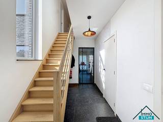 Deze recente halfopen bebouwing is gelegen in een doodlopende straat in Aartrijke en geniet van een vlotte verbinding met het openbaar vervoer en diverse winkels in de nabije omgeving.<br />Je komt de woning binnen via de inkomhal die in verbinding staat met het gastentoilet, de berging, de trap naar de eerste verdieping en de lichtrijke woonkamer met open keuken. De woonkamer biedt een mooi zicht op de tuin en beschikt over voldoende ruimte voor een gezellig zit- en eetgedeelte. De open keuken is hyper-geïnstalleerd en uitgerust met een aangenaam keukeneiland. Vanuit de keuken heb je toegang tot de berging en de ruime garage. Op de eerste verdieping bevindt zich de nachthal die toegang geeft tot twee ruime slaapkamers, een kinderkamer, een tweede toilet en de badkamer. De badkamer is voorzien van een inloopdouche en een dubbel lavabomeubel.<br />De woning is bovendien energiezuinig uitgerust met een regenwaterput van 10.000 liter met filtersysteem, 10 zonnepanelen en een thuisbatterij van 5 kW. Op het gelijkvloers is er vloerverwarming voorzien en op de eerste verdieping radiatoren, beide aangesloten op een condenserende gaswandketel. Achteraan de woning bevindt zich een aangelegde tuin met terras en een tuinhuis, waar je in alle rust kan genieten. (sted. inl.: in aanvraag)