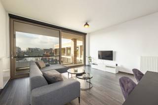 Modern appartement (bouwjaar 2016) met twee slaapkamers en zéér ruim terras op een rustige locatie nabij 't Eilandje! <br /><br />Het appartement gelegen op de vierde en hoogste verdieping bereikbaar met de lift heeft volgende indeling: via de inkomhal met apart toilet en een vestiaire betreedt men de lichtrijke leefruimte en een volledig geïnstalleerde open keuken voorzien toestellen. In het verlengde van de keuken een berging met aansluitingen voor wasmachine en droogkast. <br /><br />Via de leefruimte heeft men toegang tot het ruime zonnige zuid-west gerichte terras (ca. 25m2) met zicht op de rustige binnentuin en de Onze-Lieve-Vrouwekathedraal.<br /><br />Via de hal bereikt men een ruime eerste slaapkamer (14m2) voorzien van inbouwkasten en een tweede slaapkamer (9m2). Beiden slaapkamers geven toegang tot het zonnige terras. De badkamer is voorzien van een moderne inloopdouche en een dubbele lavabo. <br /><br />Ten slotte geniet men nog van een gemeenschappelijke inpandige fietsstalling. <br /><br />Mogelijkheid tot aankoop inpandige autostaanplaats bereikbaar met de lift aan 39.000 Euro.<br /><br />Belangrijkste troeven:<br /><br />- Toplocatie op enkele stappen van het MAS <br />- Zeer energiezuinig (EPC label A)<br />- Ruim terras met uitzicht op het binnenplein<br />- Aparte meters voor alle nutsvoorzieningen<br />- Hoge plafonds (2,89m) over heel het appartement <br /><br />90m2 bewoonbare oppervlakte cfr EPC.<br /><br />Wenst u een bezoek of meer informatie? Dan kan u ons steeds contacteren via info@dvarealestate.be of via 03/297.00.00.