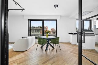 <p>Volledig furnished and recently renovated (2024) two-bedroom apartment on the 6th floor, accessible by elevator.</p>
<p>You enter the apartment via the spacious entrance hall, which leads to the bright living area with open-plan kitchen. Adjacent is a practical storage room with washing machine and dryer. From the living area you have access to the first terrace at the front, equipped with a comfortable lounge set.</p>
<p>At the rear of the apartment are two bedrooms, one furnished as a master bedroom and the other as a dressing room. The second terrace is accessible from the bedrooms. The modern bathroom is fitted with a walk-in shower and a vanity unit with washbasin.</p>
<p>The apartment also includes a private cellar storage unit and a parking space, which can optionally be rented for €150 per month.</p>
<p>The common charges amount to €100 per month and include maintenance, electricity for the common areas, waste collection, and private water consumption.</p>
<p>The gas and electricity meters are individual and will be put in the tenant’s name. The apartment is equipped with 8 solar panels, which currently cover approximately 80% of electricity consumption.</p>