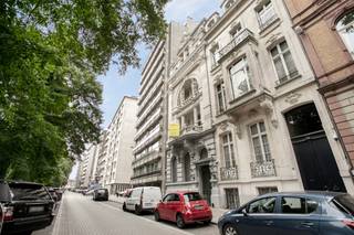 Monumentale herenwoning naar het ontwerp van architect Jean Baptiste Vereecken uit 1889. Het eigendom is gesitueerd nabij het Koning Albert- en Harmoniepak nabij verscheidene invalswegen. <br /><br />Een Eclectische voorgevel met sierlijke plint en pui uit blauwe hardsteen is verder opgebouwd in witte natuursteen. Een balkon op de eerste en tweede verdieping zijn afgewerkt met Dorische zuilen en twee hermbeelden. Een dubbele poortdeur geeft toegang tot een royale inkomhal waar het Eclecticisme wordt doorgetrokken.<br />Het schoonverdieping bestaat uit een salon, eetkamer en aansluitend tuinkamer. De ruimtes worden gekenmerkt door hoge plafonds, originele parketvloeren in combinatie met houten lambrisering en een originele haardmantel. De tuinkamer geeft toegang tot het terras en leidt vervolgens naar een ruime keuken die is ondergebracht in het voormalige koetshuis. <br />Een centrale trapzaal verbindt de verdiepingen waar zich verscheidene slaap- en badkamers bevinden. <br /><br />Een grote souterrain loopt onder de gehele herenwoning. <br /><br />Het koetshuis herbergt bijkomende verscheidene bergruimtes in de voormalige stallen. <br /><br />De achteringang van de woning biedt mogelijkheden tot parkeren. <br /><br />Het eigendom heeft steeds dienst gedaan als feestzaal met traiteuractiviteiten.