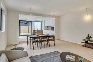 <p><strong>Vernieuwd gelijkvloers appartement in het kloppend hart van Kontich<br /></strong><strong>Welkom in Kontich: een dorp waar je de bakker nog bij naam kent, waar het leven traag genoeg bolt om ervan te genieten - terwijl je toch dicht bij al het nodige leeft. Geen wonder dat wonen hier gegeerd is! En al helemaal als je kan neerstrijken in deze karaktervolle vernieuwbouw waar élk hoekje fris en doordacht is aangepakt. Alles is hier nieuw: van gevel tot dak, van leidingen tot ramen. Hier is het thuiskomen met een hoofdletter T. Kom binnen! (doe de schoenen maar uit want 't is hier allemaal op vloerverwarming) </strong></p>
<p><strong>Welkom in de inkom</strong></p>
<p>Via de straatkant wandel je binnen in een compact gemeenschappelijk inkomsasje: netjes en overzichtelijk, met de meters van jouw unit binnen handbereik. Achter je eigen voordeur begint je verhaal écht: een lange, lichte hal die meteen de toon zet…</p>
<p><strong>Hal met mogelijkheden</strong></p>
<p>Deze gang is meer dan zomaar een doorgang: het is een ruimte op zich. Denk: plek voor wasmachine en droogkast, een elegante vestiairekast - en misschien zelfs een kunstwerk of extra opberging. Alles kan, niets moet.</p>
<p><strong>Twee kamers, eindeloos veel invullingen</strong></p>
<p>Vooraan ligt de eerste slaapkamer: perfect als logeerkamer, creatieve werkplek of bureau met zicht op het leven buiten. Achterin wacht de master: rustiger, knusser - en perfect voor nachten onder een fluffy donsdeken.</p>
<p><strong>Strak afgewerkte badkamer</strong></p>
<p>Hier kom je tot rust. Een moderne wastafel, strakke douche, zachte tegels: alles werd hier met zorg uitgekozen. Het apart toilet zorgt voor extra comfort, en de technische berging houdt alle praktische zaken mooi uit het zicht.</p>
<p><strong>Gietijzeren statement, leefruimte deluxe</strong></p>
<p>Een karaktervolle gietijzeren deur scheidt de nachthal van de leefruimte en vormt meteen een eyecatcher. De open keuken - mét keukeneiland, jawel - nodigt uit tot samen koken, lachen, tafelen. Alles is aanwezig, enkel de verlichting wacht nog op jouw persoonlijke touch.</p>
<p><strong>Zeldzaam groen</strong></p>
<p>Via grote raampartijen wandel je naar buiten, richting je eigen stukje tuin: een luxueuze zeldzaamheid in het centrum, waar je seizoensrond van kan genieten. Het terras en achterpoortje geven bovendien toegang tot de zijkant van het gebouw, handig!</p>
<p><strong>Fijn om weten</strong></p>
<p>Met een oppervlakte van 121 m², een EPC van 105 (label B) en een locatie om u tegen te zeggen, is dit een unieke kans om helemaal opnieuw te beginnen - in een pand dat volledig klaarstaat voor jouw verhaal. Tof! Bovendien kom je mogelijk in aanmerking voor een verlaagd btw-tarief van 6% - check zeker even of jij aan de voorwaarden voldoet.</p>
<p><strong>Verliefd? <u>Info@ugly.be</u> </strong></p>
<p></p>