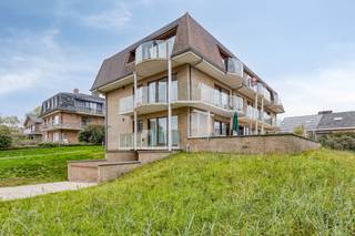 Op de tweede verdieping van de Residentie Mosduin vinden we dit piekfijn onderhouden appartement terug. Zijn ligging bij de duinen is één van de mooiste en rustigste locaties van Oostduinkerke-Bad.<br />Kortom, een unieke kans om te genieten van natuur, zon en rust in uw eigen luxueuze verblijf aan de Belgische kust.<br /><br />Dit appartement geniet van volgende indeling:
<ul>
<li>Ruim, zongericht, terras;</li>
<li>Lichtrijke woonkamer met open, geïnstalleerde keuken;</li>
<li>Apart toilet;</li>
<li>Badkamer met douchecel;</li>
<li>Extra bergruimte in het appartement;</li>
<li>Slaapkamer die uitgeeft op het terras;</li>
<li>Zéér ruime, afgewerkte zolderkamer van 48m<sup>2</sup>;</li>
<li>Gemeenschappelijke fietsenberging;</li>
<li>Mogelijkheid tot aankoop van extra brede garagebox (€40.000);</li>
</ul>
Enkele troeven:
<ul>
<li>Gunstige EPC-score van 226;</li>
<li>Centrale doch rustige ligging;</li>
<li>volledig instapklaar;</li>
</ul>
Benieuwd naar deze eigendom? Contacteer ons op het nummer 058 24 00 15 voor een bezoek ter plaatse.