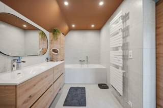 Op de Tiensesteenweg 69 te Bunsbeek bevindt zich deze instapklare eigendom die wonen en werken perfect combineert. De woning beschikt over een inkomhal, een leefruimte, een eetplaats en een volledig uitgeruste keuken. Een polyvalente ruimte kan dienen als tweede inkom, waardoor het woongedeelte eenvoudig kan worden afgescheiden van het handelspand. Op de eerste verdieping bevinden zich drie volwaardige slaapkamers en een recent vernieuwde badkamer uit 2025. Verder is er een kelder en een ruime garage van 40 m² met doorgang naar de mooie tuin met terras. Aan de woning zijn vier private staanplaatsen voorzien, inclusief een laadpaal. Daarnaast is de woning uitgerust met 34 zonnepanelen en een batterij, wat zorgt voor een energiezuinige werking. Aansluitend bevindt zich het handelsgedeelte, momenteel ingericht als frituur, met bureauruimte, diepvriescel, opslagruimte, keuken en zitplaatsen voor klanten. (In zijn totaliteit is dit goed voor 104,20m² aan ruimtes die ingedeeld zijn voor de handelszaak.) De ruime veranda biedt extra zitplaatsen en er is voldoende parkeergelegenheid voor klanten. Een unieke opportuniteit met sterke commerciële troeven en comfortabel wonen.<br /><br />Verplichte overname huidig handelsfonds tegen een extra kost van € 220.000.
