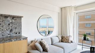 <p>Aan het iconische Rubensplein in Knokke, op een uitzonderlijke ligging op de hoek van de Zeedijk, bevindt zich dit prachtig gerenoveerde appartement met adembenemend frontaal zeezicht. Dankzij de zuidwestelijke oriëntatie geniet u hier niet alleen van een magnifiek vergezicht over zee, maar ook van zonlicht tot in de avonduren – een absolute troef.</p>
<p>De inkomhal verwelkomt u met een praktische vestiaire en gastentoilet. De hoofdslaapkamer beschikt over ruime ingemaakte kasten en sluit aan op een luxueus afgewerkte douchekamer met een tweede toilet. Ook de tweede slaapkamer is voorzien van praktische ingebouwde kasten en biedt voldoende ruimte voor een volwaardig bed of logeeropstelling.</p>
<p>De lichtrijke leefruimte baadt in het zonlicht dankzij de brede raampartijen aan de zeekant en kijkt uit over zowel het strand als het levendige Rubensplein. De open keuken vormt een stijlvol en tegelijk functioneel geheel, uitgerust met hoogwaardige Miele-toestellen, een wijnkast en een aparte diepvriezer – perfect voor wie comfort en kwaliteit weet te appreciëren.</p>
<p>Het volledige appartement werd afgewerkt met smaakvolle mortex vloeren voorzien van vloerverwarming, wat zorgt voor een strak en warm interieurgevoel.</p>
<p>Extra troeven zijn de private kelderberging en de vlot toegankelijke fietsenberging in het gebouw.</p>
<p>Een pareltje op één van de meest gegeerde locaties van Knokke, waar zeezicht, zon en elegantie samenkomen.<br />EPC: 91 kWh/m²/j [A-label]</p>