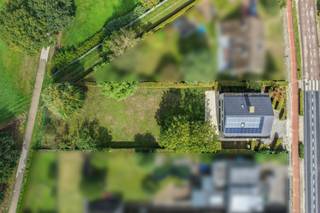 Op een toplocatie in Ranst, omgeven door groen en met een prachtig verzicht, bevindt zich deze zeer ruime en uitstekend onderhouden villa. De combinatie van een lichtrijk interieur, royale leefruimtes, een ruime tuin en een uitstekende energiescore maakt van deze woning een bijzonder aangename thuis. Ook de Fietsostrade (Safi-spoor) sluit rechtstreeks aan op de tuin, ideaal voor wie graag met de fiets op pad gaat.<br /><br />Via de ruime oprit bereikt u de woning en de dubbele garage. Bij het betreden van de inkomhal valt meteen de aangename lichtinval en het gevoel van ruimte op. De royale leefruimte geniet dankzij de grote raampartijen van veel natuurlijk licht en biedt een mooi zicht op de achterliggende tuin. Aansluitend bevindt zich de gerenoveerde keuken, die voorzien is van alle nodige toestellen. Op het gelijkvloers bevindt zich bovendien een afzonderlijke bureauruimte. Van hieruit leidt een trap naar een bijkomend bureau of polyvalente ruimte op de eerste verdieping, ideaal als praktijk, thuiskantoor of voor een vrij beroep met de mogelijkheid een aparte inkom te creëren. <br /><br />Vanuit de leefruimte krijgt u toegang tot het ruime terras en de prachtige tuin. De tuin is zowel breed als diep en vormt dankzij de volwassen bomen en het open zicht op het omliggende groen een heerlijke plek om in alle rust te genieten. Bovendien werd de tuin onderhoudsvriendelijk aangelegd. Een bijkomende troef is de servitudeweg, waardoor de tuin ook langs de achterzijde toegankelijk is met fiets, wagen of aanhangwagen.<br /><br />Een stijlvolle marmeren trap leidt naar de eerste verdieping. Hier bevinden zich vier ruime slaapkamers voorzien van parketvloer en twee badkamers. De ene badkamer is uitgerust met een ligbad, terwijl de tweede beschikt over een bijzonder ruime inloopdouche. Daarnaast bevindt zich hier de eerder vermelde polyvalente ruimte/bureauruimte, die via het bureau op het gelijkvloers ook bereikbaar is.<br /><br />Ook aan bergruimte en verdere mogelijkheden is er geen gebrek. Via een vaste trap bereikt u de zeer ruime zolderverdieping, die nog tal van mogelijkheden biedt en naar eigen behoefte verder kan worden ingevuld, voorzien van opbergkasten langs beide zijden. De woning is tevens volledig onderkelderd met zes ruime kelders.<br /><br />Op energetisch vlak scoort de woning eveneens uitstekend met een EPC-label B. De villa beschikt onder meer over dakisolatie, vloerisolatie, muurisolatie, PVC-ramen met dubbele beglazing, zonnepanelen en centrale verwarming op gas met een condensatieketel, gecombineerd met warmtepomp op alle slaapkamers, bureauruimten en zolder.<br /><br />Contacteer Vincent voor een bezoek ter plaatse via Vincent@reds.be of +32 475 21 00 86.