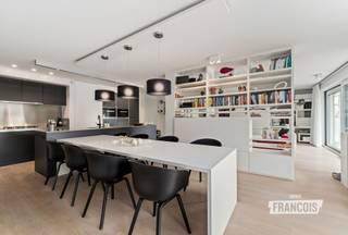Dit uitzonderlijk ruim en luxueus appartement is gelegen in residentie Park Leopold II 1 te Wenduine op de eerste verdieping en op een rustige ligging net buiten het centrum. Dankzij de samenvoeging van twee appartementen geniet dit eigendom van een bijzonder royale bewoonbare oppervlakte van maar liefst 146 m². Bovendien werd voor de inrichting en afwerking samengewerkt met een architect, wat resulteert in een feilloos afgewerkt en modern geheel met een stijlvolle uitstraling.<br /><br />Bij het betreden van het appartement springt de hoogwaardige afwerking meteen in het oog. De ruime inkomhal, voorzien van praktische ingemaakte kasten, vormt de perfecte binnenkomer en biedt toegang tot de verschillende ruimtes van het appartement. Via een elegante deur bereikt men de leefruimte waar een organische overgang en het grote schuifraam zorgen voor een bijzonder open en lichtrijk gevoel.<br /><br />De woonkamer werd uiterst doordacht ingericht met een gezellige zithoek, een geïntegreerde bureauruimte en een centrale boekenkast die op subtiele wijze de scheiding vormt tussen de eetplaats en de leefruimte. De stijlvolle open keuken is uitgerust met alle moderne comfort en hoogwaardige toestellen. Eyecatcher van de ruimte is zonder twijfel de gezellige gashaard die extra sfeer creëert. Centraal in de keuken bevindt zich bovendien een praktische berging waar niet alleen extra opbergruimte voorzien werd, maar waar ook alle technische installaties van het appartement netjes gecentraliseerd zijn.<br /><br />Via de leefruimte bereikt men de eerste ruime slaapkamer, die beschikt over een ensuite badkamer met douche, lavabo en toilet. Aan de andere zijde van het appartement bevinden zich nog twee volwaardige slaapkamers, beide voorzien van ingemaakte kasten en met toegang tot het tweede terras van het appartement. Verder is er nog een tweede badkamer aanwezig, uitgerust met een inloopdouche en dubbele lavabo. In de inkomhal bevindt zich bovendien nog een apart gastentoilet.<br /><br />Het appartement beschikt over dubbele beglazing, individuele centrale verwarming op aardgas en conforme elektriciteit. Dankzij de gunstige EPC-score vormt dit appartement niet alleen een stijlvolle, maar ook energiezuinige woonoplossing.<br /><br />Ten slotte bevindt zich in de kelderverdieping ook een dubbele garage, die verplicht aan te kopen is voor 100.000 EUR.<br /><br />Kortom, een unieke kans voor wie op zoek is naar een luxueus afgewerkt appartement met royale volumes, veel lichtinval en een uitstekende ligging aan de Belgische kust. Ideaal als vaste woonplaats, tweede verblijf of investering. Plan nu uw bezoek in!<br /><br />