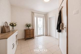 Voor meer info en foto’s, surf naar www.swevers.be – Ruim en instapklaar gelijkvloers appartement van 191 m² aan de Generaal de Krahestraat 106 bus 1 in Leopoldsburg. Deze eigendom combineert het comfort van gelijkvloers wonen met de ruimte van een gezinswoning. De flexibele indeling laat een klassieke gezinswoning of een kangoeroe-/zorgwoning toe, dankzij twee aparte inkomhallen, twee leefruimtes en twee badkamers. Afhankelijk van de gekozen indeling beschikt het appartement over twee tot vier slaapkamers. De leefruimte met open keuken bevindt zich achteraan en sluit aan op een praktische berging en wasplaats. Daarnaast zijn er nog extra ruimtes die ideaal zijn als bureau, hobbykamer of speelkamer. Het appartement werd recent gerenoveerd en biedt hedendaags wooncomfort met zonnepanelen, warmtepomp, aardgasverwarming, airconditioning, mechanische ventilatie en rolluiken. Buiten geniet u van een gezellig terras en een zonnig zuidwestgericht terras, ideaal om te ontspannen. Ook de parkeermogelijkheden zijn een grote troef, met een ruime inpandige garage geschikt voor een hoge SUV of bestelwagen, twee vergunde parkeerplaatsen en een extra staanplaats voor de garage. De centrale ligging is uitstekend, op wandelafstand van restaurants, openbaar vervoer, scholen, winkels en ontspanning. Dankzij de ruime indeling, dubbele bewoningsmogelijkheid, energiezuinige technieken en uitstekende bereikbaarheid is dit een veelzijdige eigendom die perfect aansluit bij grote gezinnen, thuiswerkers of wie op zoek is naar een woning met zorgmogelijkheden. Voor meer informatie, bel 011 255 155. Bron bewoonbare oppervlakte: EPC – verslag.
