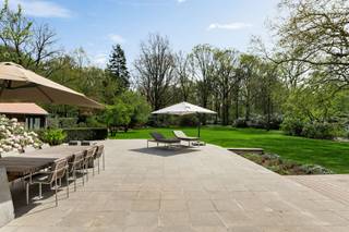 <p><span> </span></p><p><span>Deze ruime en kwalitatief afgewerkte villa is gelegen op een rustig en groen perceel en geeft comfort, privacy en snelle toegang naar alle snelwegen. De woning werd praktisch ingedeeld en biedt tal van mogelijkheden voor wonen, werken en ontspannen, zowel binnen als buiten. </span></p><p><span> </span></p><p><span>U betreedt de woning via de inkomhal met gastentoilet en directe toegang tot de bureauruimte/bibliotheek. Dit bureel is dus ideaal gelegen om mensen te ontvangen zonder dat men in de rest van de woning moet komen.  </span></p><p><span>De woonkamer is zeer ruim en vormt het centrale gedeelte van de woning. Deze leefruimte biedt een prachtig panoramisch zicht over de tuin. De living werd ingedeeld met een ruime zithoek bij de open haard en formele eetplaats. Aansluitend bevindt zich de leefkeuken met ontbijtzone,  welke praktisch werd ingericht en rechtstreeks verbonden is met de leefruimtes. Achter de keuken bevindt zich nog een tweede gastentoilet evenals een aparte audio- of homecinemaruimte, met daarboven een nog aparte studio. </span></p><p><span> </span></p><p><span>1e Verdieping</span></p><p><span>Via de centraal gelegen trap bereikt u de nachthal op de eerste verdieping. Hier bevindt zich een eerste ruime slaapkamer met aansluitende badkamer die gedeeld wordt met een achterliggende tweede slaapkamer. Verder is daarnaast een praktische wasplaats op deze verdieping. </span></p><p><span>De grote mastersuite beschikt over een ruime slaapkamer met aansluitende dressing (voorheen nog extra slaapkamer) en een royale badkamer voorzien van sauna en een ruime inloopdouche. Aan de voorzijde van de woning bevindt zich een studeerkamer welke ook deel uitmaakt van de mastersuite en welke eveneens dienst kan doen als een tweede dressing. Deze avond study is voorzien van een open haard.</span></p><p><span> </span></p><p><span>2e Verdieping</span></p><p><span>Ook de tweede verdieping werd volledig benut. Hier bevindt zich een bergzolder met ingemaakte kasten welke ideaal dienst doet als opbergruimte. Ook werd op de tweede verdieping een extra suite ingericht met aansluitende badkamer evenals een aparte studeer- of bibliotheekruimte. Daarnaast bevindt zich op deze verdieping nog een slaapkamer. </span></p><p><span> </span></p><p><span>Kelder</span></p><p><span>De woning is volledig onderkelderd. Hier bevinden zich diverse technische ruimtes en praktische bergruimtes. Tevens zijn er twee royale geklimatiseerde wijnkelders aanwezig. </span></p><p><span> </span></p><p><span>Garages en parkeren</span></p><p><span>Vooraan het perceel bevindt zich een ruime parkeerplaats met plaats voor circa 13 wagens evenals een carport naast de woning voor twee frequent gebruikte voertuigen, vlakbij de woning. </span></p><p><span>Achteraan het perceel, langs de oprit die aan de rand van het domein loopt, bevindt zich een afzonderlijke garage met plaats voor negen autos. </span></p><p><span> </span></p><p><span>Tuin en buitenruimtes</span></p><p><span>De tuin biedt u volledige privacy. Er is een ideaal gelegen zwembad dat recent gerenoveerd werd met ruime terrassen en aansluitend een poolhouse met leefruimte, douche, toilet en sauna. </span></p><p><span>Achteraan op het perceel bevindt zich een charmante chalet met twee slaapkamers, een keuken en een woonkamer, ideaal als gastenverblijf. </span></p><p><span> </span></p><p><span>Bijzonderheden</span></p><p><span>Deze exclusieve villa combineert royale woonruimtes met veel mogelijkheden tot ontspanning zoals zwembad, wellness en homecinema. De villa is zowel geschikt voor een groot gezin als voor een combinatie van wonen en werken. Dankzij onder meer de ruime parkeermogelijkheden, de volledig onderkelderde woning en het bijkomende gastenverblijf biedt dit eigendom een uitzonderlijk wooncomfort in een groene omgeving nabij het centrum van Brasschaat. </span></p><p><span> </span></p><p><span>Meer inlichtingen via ons kantoor.</span></p>