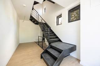 Indeling<br /><br /><strong>Gelijkvloers - eerste verdieping<br /></strong><br />Bij het betreden van dit stijlvolle duplexappartement wordt u verwelkomd in een royale inkomhal, waar de karaktervolle industriële trap meteen de toon zet. Op deze verdieping bevinden zich tevens een zeer ruime was-/bergruimte en een gastentoilet.<br /><br />De lichtrijke leefruimte straalt warmte en elegantie uit dankzij de hoogwaardige stenen vloer met houtlook, die naadloos doorloopt in de open leefkeuken. Deze luxueuze keuken werd uitgerust met kwalitatieve Bosch- en AEG-toestellen, een royaal kookeiland en een ruim werkblad. Vanuit de keuken geniet u bovendien van een prachtig groen zicht op de tuin.<br />Aansluitend bevindt zich het ruime dakterras, waar binnen- en buitenleven harmonieus in elkaar overvloeien. Via een buitentrap bereikt u de diepe privatieve tuin.<br /><br />Verder beschikt deze verdieping over een ruime master bedroom met een stijlvolle en-suite badkamer, uitgerust met een royale inloopdouche, dubbele wastafel en toilet.<br /><br /><strong>Tweede verdieping<br /></strong><br />Op de bovenverdieping bevinden zich nog twee volwaardige slaapkamers. Deze delen een tweede, smaakvol afgewerkte badkamer met inloopdouche en wastafel, aangevuld met een apart toilet.<br /><br />Achteraan het gebouw geniet u van twee privatieve autostaanplaatsen, vlot bereikbaar via een aparte inrit.<br /><br />Tot slot beschikt het appartement over een droge privatieve kelderberging, ideaal als extra opslagruimte.<br /><br />Bijzonderheden:<br />B-label, koelinstallatie via lucht-lucht warmtepomp, verwarming radiatoren via cv gas, videofoonsysteem in elke ruimte, zwarte aluminium ramen, Vg-Wg-Gvv-Gvkr-Gmo