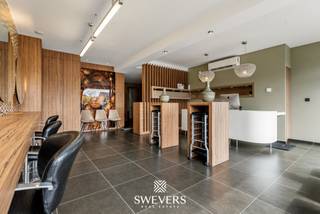 Voor meer info en foto’s, surf naar www.swevers.be – Instapklare commerciële ruimte met uitstekende zichtbaarheid langs de Kempische Steenweg 378 in Hasselt. Deze volledig gerenoveerde handelsruimte van 74 m², gebouwd in 1988 en gelegen op een perceel van 10 are 44 centiare, bevindt zich in een verzorgde staat en is momenteel ingericht als kapsalon. Dankzij de praktische indeling is het pand echter ook geschikt voor tal van andere commerciële of dienstverlenende activiteiten. De open handelsruimte wordt aangevuld met een aparte keuken (8,9 m²), een afzonderlijk toilet en een handige berging (2,9 m²). De aanwezige maatwerkinrichting zorgt voor een professionele uitstraling en laat een nieuwe eigenaar toe om snel van start te gaan. Het pand beschikt over een gunstig EPC-label A, is asbestveilig en heeft lage gemeenschappelijke kosten. Voor de deur zijn publieke parkeerplaatsen beschikbaar. Daarnaast kunnen optioneel twee garageboxen worden aangekocht voor 35.000 euro. Tijdens de renovatie werden onder meer de ramen vernieuwd en werd kwalitatief maatwerk voorzien. De ligging is een absolute troef: op 4,2 km van de autosnelweg, met openbaar vervoer op 300 meter, winkels en scholen op 450 meter en restaurants op 600 meter. Een representatieve handelsruimte met uitstekende bereikbaarheid en maximale visibiliteit, ideaal om uw zaak verder uit te bouwen. Voor meer informatie, bel 011 255 155. Bron bewoonbare oppervlakte: EPC – verslag.
