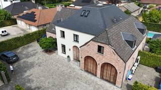 Deze statige villa werd gebouwd in 2016 met oog voor kwalitatieve materialen en comfort.<br /><br />Gelegen aan de Bouwelsesteenweg geniet deze woning van een uitstekende combinatie van bereikbaarheid en een groene omgeving. Via de steenweg zijn zowel Nijlen als Bouwel en de belangrijke verbindingswegen gemakkelijk bereikbaar. Bovendien liggen winkels, scholen, openbaar vervoer en allerhande dagelijkse voorzieningen in de onmiddellijke omgeving.<br /><br />De verzorgde oprit en de inkomhal met vide geven het geheel meteen een fraaie eerste indruk. De leefruimte dankt haar grandeur aan de hoge plafonds, de dubbele inkomdeur en de glazen wand met stalen frame die voor een vloeiende overgang zorgt tussen eet- en zitkamer. De ruime leefkeuken met een imposant keukeneiland is volledig geïnstalleerd. De keuken is uitgevoerd in een degelijk materiaalduo van hout en natuursteen en straalt een tijdloze duurzaamheid uit.<br /><br />De aangelegde en omheinde tuin met verwarmd zwembad en overdekte tuinpaviljoen voorzien van een gezellig gasvuur is een absolute meerwaarde. De volgroeide hagen zorgen voor een ongestoorde privésfeer. Het perceel heeft een totale oppervlakte van 11a 65ca en een mooie breedte van 30lm.<br /><br />De geïnstalleerde bureauruimte maakt de woning daarenboven interessant voor thuiswerkers.<br /><br />De rechtervleugel op het verdiep bestaat uit de masterbedroom met annex dressing en ruime ensuite badkamer met ligbad, dubbele douche, dubbele wastafel en toilet.<br /><br />Verder bestaat de eerste verdieping uit 2 slaapkamers, een tweede badkamer met inloopdouche en lavabo en een apart toilet.<br /><br />Het tweede verdiep is toegankelijk via een vaste trap. Deze extra ruimte is volledig afgewerkt en voorzien van maatkasten en airco.<br /><br />Ten slotte is er op het gelijkvloers een gastentoilet, een inpandige dubbele garage met een hydraulisch platformlift naar de ruime kelder, een aparte berging met maatkasten en wasvoorzieningen.<br /><br />De kelder is opgedeeld in verschillende compartimenten met onder meer een fitnessruimte en ontspanningsruimte.<br /><br />Kortom, een parel van een woning waarbij functionaliteit, luxe en ruimtelijkheid de voornaamste sleutelwoorden zijn.
