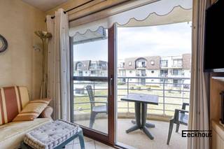 Gemeubeld appartement met terras gelegen op de eerste verdieping in een residentieel domein genaamd 'Blutsyde' met gemeenschappelijk verwarmd zwembad, op 10 minuten wandelafstand van duinen, zee en strand!<br />Indeling: inkomhal, lichtrijke leefruimte met open ingerichte keuken, terras, 1 slaapkamer, berging, badkamer met douche, toilet en lavabomeubel.<br />Autostaanplaats inbegrepen.