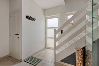 Deze ruime en instapklare woning uit 2002 ligt in een rustige omgeving in Opoeteren. Het gaat over een vrijstaande woning, gelegen op een perceel van 4a 78ca met wandel- en natuurgebieden vlakbij. Ook heeft het een vlotte verbinding naar As en Opglabbeek.<br /><br />Bij het betreden van de woning kom je terecht in de inkomhal dat voorzien is van een apart gastentoilet. Van hieruit stap je door naar de leefruimte in het hart van de woning. Aan de voorzijde ligt een praktische bureau/zithoek en aan de achterzijde bevindt zich de recent gerenoveerde keuken met eiland, koelkast, inductie kookplaat, oven en microgolfoven. Vanuit de keuken bereik je het overdekte terras, een berging en de trap die je naar de kelder brengt.<br /><br />Op de eerste verdieping brengt de nachthal je naar drie volwaardige slaapkamers en een ruime badkamer voorzien van dubbele wastafel, ligbad, douche en toilet. Vanuit de badkamer heb je bovendien toegang tot een vierde kamer. In de nachthal is er verder nog een luik naar de zolder.<br /><br />In de kelder vind je een grote open ruimte met garagepoort, aangevuld met twee aparte kamers die als berging of hobbyruimte gebruikt kunnen worden.<br /><br />Troeven van de woning:<br />- Instapklaar en hoogwaardig afgewerkt<br />- Uitgerust met 10 zonnepanelen en airco’s<br />- EPC en elektrische installatie conform<br />- Volledig onderkelderd met inpandige garage