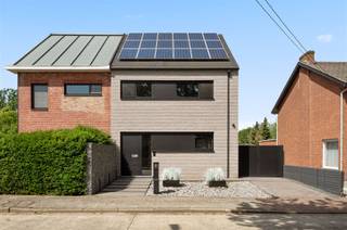 <p><span>Aan het einde van de rustige, doodlopende Pruimelaarstraat, ligt deze luxueus afgewerkte woning (2019) met een verzorgd aangelegde tuin, camera’s, alu antraciet buitenschrijnwerk (Reynaers), wachtleiding voor oplaadpunt, alu poort, geïntegreerde pakketbrievenbus, maatkasten, etc. De gelijkvloerse verdieping is voorzien van hoogwaardige designbinnendeuren van Anyway Doors. De EPC-score van 89 (Label A) werd bereikt door integratie van: algemene vloerverwarming, condensatieketel, 18 zonnepanelen en dikke isolatielagen. De ruime leefruimte beschikt over een tv-meubel (maatwerk), geïntegreerde gashaard (M-Design), afstandsbediende elektrische binnenlamellen (Somfy), ingebouwde speakers, grote alu schuiframen (Reynaers), gepolierde betonvloer en plafondhoge deuren (Nordex). Let in de aangelegde tuin met veel privacy op de prijzige overdekte terrasconstructie (Brustor), de robotmaaier, het bijgebouw en de tuinverlichting (app). In de luxueuze keuken (Grando), spotten we veel (verborgen) bergruimte, Dekton werkbladen, een groot kookeiland (6 zitplaatsen), Miele toestellen (oven, microgolfoven, koffiemachine, koelkast, diepvries), plus een kookplaat met geïntegreerde afzuiging. Opbergruimte is beschikbaar in een wasplaats, een droge kelder en een technische ruimte. In de toiletten is zelfs de rolhouder geïntegreerd in de muur. De luxe-badkamer is groot genoeg voor de inloopdouche (stalen deur) en het dubbele badkamermeubel (maatwerk). Alle kamers bieden plaats voor een dubbel bed. De exclusieve handgemaakte trap van Genico met Corian afwerking en geïntegreerde LED-verlichting, geeft aan van welk hoog niveau de afwerking wel is.</span></p>