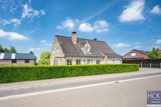 <strong>De ligging</strong><br />Deze alleenstaande villa is rustig gelegen in een <strong>residentiële omgeving</strong>, doch op amper 5 min. rijden van het centrum van Kruishoutem dewelke voorzien is van allerhande winkels, horeca en overige faciliteiten. Dankzij diverse verbindingswegen zijn de aanpalende randgemeenten Deinze/Nazareth/Gavere/Zulte/Waregem allen heel vlot bereikbaar, tevens bereikt u op amper 30. min. rijden zowel centrumstad Kortrijk als Gent. Kortom, de ligging combineert het beste van twee werelden: <strong>een rustige groene woonomgeving </strong>en <strong>goede bereikbaarheid</strong>!<br /><br /><strong>De woning</strong><br />De villa zelf is <strong>exceptioneel ruim</strong> dankzij zijn bruikbare vloeroppervlakte van maar liefst 316 m² en staat op een <strong>royaal perceel </strong>van 3550 m² groot. De woning werd ontworpen in een <strong>tijdloze stijl met een uitgesproken landelijke ziel</strong>. Binnen ademt de woning warmte en karakter, met <strong>duurzame materialen </strong>die tijdloos blijven.<br />De woning biedt vandaag drie slaapkamers, waaronder één op het gelijkvloers. Met daarenboven capaciteit voor diverse extra kamers.<br />De <strong>praktische indeling</strong> en de directe toegang vanuit de inkomhal tot de kamer beneden maken dit huis perfect voor wie wonen en werken wil combineren.<br /><br /><strong>De indeling</strong><br />Gelijkvloers: inkom - afzonderlijk toilet - living - keuken - slaapkamer - badkamer - inpandige garage annex wasplaats;<br />Verdieping 1: nachthal - 2 slaapkamers - badkamer - zolderruimte dewelke desgewenst nog kan ingericht worden;<br />Verdieping 2: niet ingerichte zolderruimte; <br />Kelder. <br /><br />Aangelegde tuin met terras en bijgebouw.<br /><br /><strong>Kenmerken</strong><br />- oppervlakte perceel: 3550 m² <br />- bruikbare vloeroppervlakte: 316 m²<br />- CV via stookolie<br />- PVC raamprofielen met dubbel glas<br />- regenwater: 10.000 liter<br />- EPC: 254 kWh/m² jaar - C-label<br /><br /><strong>Troeven</strong><br />- uitmuntend gelegen!!<br />- kraaknet onderhouden!!<br />- exceptioneel ruim!!<br />- géén renovatieplicht, asbestveilig!!<br /><br />Voor meer informatie of een bezoek reageer via het contactformulier of stuur naar info@hckinvest.be