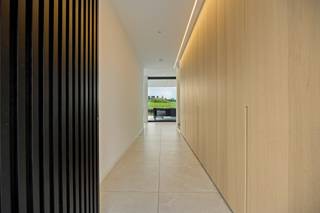 <p>–<strong>Interessante aankoopformule onder registratierechten</strong>–</p><h2><strong>Architecturale nieuwbouwvilla te Vissenaken:ongeziene luxe en ruimte, hoogwaardig afgewerkt</strong></h2><p>Dat tegenpolen elkaar aantrekken, bewijst deze architecturale nieuwbouwvilla uit 2023. Ze laat zich kenmerken door een robuust silhouet met een verfijnd karakter. Een ware statementwoning die tegelijkertijd sereniteit hoog in het vaandel draagt. Hier beleeft u gegarandeerd steeds het beste van twee, en veel meer, werelden.</p><p>Op een perceel van circa 30 are treft u deze vondst, gekenmerkt door een zandkleurige gevel met een zeldzame vorm van tijdloosheid. Aan de straatzijde houdt de architectuur zich bewust meer gesloten: een doordachte keuze die privacy creëert en het binnenleven afschermt van de straat. Het strakke design omhult maar liefst 500 m² bewoonbare oppervlakte en wordt omringd door – nu nog vrij in te richten – flora en vermaak. Van een oranjerie of moestuin tot een natuurlijke zwemvijver, maar evengoed een poolhouse met luxe buitenkeuken. Met een glas champagne in de hand droomt u vanuit de jacuzzi alvast van dat buitenplan.</p><p>Waar de woning zich vooraan bewust afsluit van de straat, opent ze zich achteraan volledig naar het landschap. Dankzij de achterste glasgevel lijken interieur en landschap door elkaar te zweven. Op het gelijkvloers geniet u zo van een open en lichtrijke leefruimte, met nog aanpalend twee flexibel inzetbare ruimtes, ideaal als bureau, atelier, speelkamer, extra leefruimte of slaapkamer.</p><p>Overlopend in de high-end, hoog afgewerkte keuken: inclusief Dekton werkblad, premium Siemens toestellen en maatwerk tot in de kleinste lade. Minimalistisch ogend, maximalistisch in gebruik. En de technologie, die verdwijnt in het maatwerk dankzij onder andere de ingewerkte dampkap en toegang tot het volledig geïntegreerde Loxone Smart Home systeem. Verlichting, screens, audio en meer worden zo met één knop bediend terwijl u hetzelfde doet voor uw gasten.</p><p>Op de eerste etage bevinden zich vier slaapkamers. De hoofdslaapkamer vormt samen met de ruime dressing en ensuite badkamer een mooi geheel: ontwaken met een weids uitzicht, vervolgens door naar de dressing en aansluitend de badkamer. Die werd verfijnd afgewerkt met onder meer een dubbele wastafel van Axor en een bad met corian afwerking. Ook de tweede badkamer op deze verdieping beschikt over een moderne inloopdouche. Comfort en afwerking trekken hier duidelijk dezelfde lijn.</p><p>Op de bovenste etage treft u letterlijk vrijheid van het hoogste niveau. Want deze polyvalente verdieping kan bestemd worden tot exclusief thuiskantoor, maar evengoed tot bibliotheek, ruimte voor een vrij beroep of zelfs kangoeroewoning. En dankzij de lift navigeert u in alle discretie tussen de etages zonder het private woondeel te doorkruisen. Een uitzonderlijke troef met ook een toekomstgericht doel.</p><p>En eveneens in de kelderverdieping liggen de mogelijkheden letterlijk aan de voeten: van een cosy cinema tot een exclusieve wijnkelder, of van een homegym tot een infraroodcabine. Van spanning tot ontspanning: wat u kiest, beleeft u binnenkort thuis. Tot slot geniet u royaal en blijft de impact op uw energiefactuur toch beperkt, want dankzij een geothermische warmtepomp, passieve koeling, zonnepanelen en driedubbele beglazing geniet u van een uitzonderlijk laag E-peil E5.</p><figure><div></div></figure><p></p>