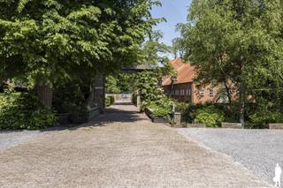 <strong>Uniek gelegen eigendom 'domein 'Klein Hoef'', gekend als de oudste hoeve van Retie, nabij centrum en uitstekend commercieel doch natuurlijk-groen gelegen aan de Retiese ring richting Kasterlee/Oud-Turnhout en nabij de Nederlandse grens. Het onroerend goed, gelegen op een perceel van maar liefst 11.465m² bestaat uit (i) een ruime zaak (ca. 500m²) waarin thans klassebrasserie 'De Klynhoeve' is gevestigd (handelshuur eindigt 2028), (ii) een woning met riant stalgebouw voor opslag (totaal ca. 340m²), en (iii) enkele bijgebouwen (oude stal achteraan, overdekte opslag vooraan). </strong><br /><br /><strong>Het geheel biedt een unieke kans voor ondernemers/investeerders die dromen van een bloeiende horecazaak met riante woongelegenheden. Het eigendom biedt tal van mogelijkheden gelet op de verschillende gebouwen en de private ligging; bovendien omgeven door uitgestrekte natuurbossen (onder meer richting Groendomein Prinsenpark) en verschillende fiets- en wandelroutes. Er is een energielabel D voor woonhuis met stal (geen renovatieverplichting) en een label G voor de brasserie. </strong><br /><br /><span>Dit uitzonderlijke vastgoedgeheel dient gerenoveerd te worden (o.a. elektriciteit, renovatie woning, aanleg tuin). </span><br /><br /><span>Aangrenzend zijn er legio parkeermogelijkheden en liggen enkele hectaren grond die tevens aangekocht kunnen worden: info op aanvraag.<br /><br /></span><strong></strong><span>Algemeen</span><strong>:<br /></strong>Aan de Kleine Nete gelegen omwalde hoevesite met een eeuwenoude oorsprong; de oudste bronnen vermelden het hoevecomplex reeds begin 16e en midden 17e eeuw. De hoeve met bijgebouwen zoals deze thans doorgaat bestaat sinds begin 20ste eeuw uit losstaande bestanddelen, rondom een erf geschikt: een woonstalhuis (nok loodrecht op de straat), een parallel gelegen schuur met bijschuurtje waarin thans Brasserie 'Klynhoeve' wordt uitgebaat, een toegangspoort.<br /><br />De hoevesite met oud grachtensysteem werd in de 20ste eeuw verder uitgewerkt en geïntegreerd in het nieuwe kasteeldomein; de hoeve diende een bloeiend landbouwbedrijf te worden dat het kasteel en ook de dorpelingen voorzag van groenten, fruit, melk en vlees. Zo kreeg de 'Klein Hoef' een gestructureerde aanleg met een moestuin, een omgrachte kleine en grote boomgaard, en een essenbos. De eiken van de Grote Dreef en andere aanplantingen langs de grachten vormden een natuurlijk scherm tussen park en hoevesite.<br /><br /><span>Horecazaak (brasseriegebouw)</span>:<br />Van de huidige hoevegebouwen zijn de monumentale schuur en toegangspoort de oudst bewaarde. Het huidige hoofdschuurvolume is ca. 1992 sterk verbouwd en gerenoveerd tot café-brasserie. Dit gebouw bestaat uit een verbruikzaal, keuken, opslag en wintertuin; er is verder ook een terras aanwezig. Een suggestie van het de binnenkant/het interieur van de brasserie kunt u bekijken via de website van de brasserie (https://deklynhoeve.be/).<br /><br />Het handelsfonds is niet mee over te nemen - handelshuur eindigt in 2028: informatie op aanvraag.<br /><br /><span>Woongedeelte en stallingen</span>:<br />Van het oorspronkelijk woonstalhuis werd in 1952 de stal en in 1963 ook het woonhuis vervangen door de huidige. Deze delen van het onroerend goed verdienen een totaalrenovatie. Voor de bouw van het woonhuis zijn evenwel degelijke materialen gebruikt: arduinen dorpels, dak in rode pannen, houten ramen en kornissen.<br /><br />De woning beschikt over een ruime zitplaats en leefruimte. Er zijn 4 slaapkamers voorzien en een riante zolder. De woning is tevens onderkelderd (kleine provisiekelder - niet droog). De aan de woning aansluitende stalling beschikt over ca. 215m² extra aan stal-/opslagruimte; en biedt zo legio feitelijke mogelijkheden naar invulling toe. Er is gasaansluiting aanwezig.