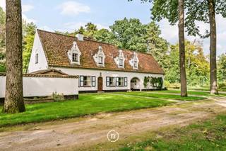 Située le long de la Brugse Steenweg à Maldegem, cette imposante demeure flamande s’étend sur un exceptionnel domaine verdoyant d’environ 2 hectares. Avec une généreuse surface habitable d’environ 420 m², une architecture de caractère et un magnifique environnement paysager, cette propriété offre une combinaison unique d’espace, d’intimité et d’authenticité.<br /><br />Construite en 1973, la maison dégage tout le charme d’une demeure classique. Les matériaux authentiques ont été soigneusement préservés au fil des années. Les portes en chêne ainsi que les sols de caractère en carreaux anciens, élégamment bordés de chêne, confèrent à l’ensemble une atmosphère chaleureuse et intemporelle.<br /><br />Avec environ 420 m² habitables, la propriété offre de très généreux espaces de vie et de nombreuses possibilités pour ceux qui recherchent une vaste maison familiale ou souhaitent combiner habitation, travail et loisirs. Une grande cave et un grenier offrent également de nombreux espaces supplémentaires de rangement ou de loisirs.<br /><br />La maison bénéficie de plusieurs équipements de confort, notamment le chauffage au gaz, le double vitrage et la climatisation dans la cuisine et la chambre principale. Deux garages équipés de portes automatiques permettent d’accueillir plusieurs véhicules tout en offrant un espace de rangement supplémentaire. Un espace séparé pour le stockage du bois est également prévu.<br /><br />Le véritable atout de cette propriété est son terrain d’environ 2 hectares situé en zone de parc. Le vaste jardin soigneusement entretenu, agrémenté d’arbres fruitiers, était à l’origine aménagé en verger et offre un environnement particulièrement verdoyant et champêtre.<br /><br />Un charmant petit pont enjambant le fossé rappelle l’ancienne configuration en îlot de la parcelle et renforce le caractère singulier du domaine. Le terrain est clôturé et dispose d’un puits ainsi que d’un second accès vers la route principale.<br /><br />Une demeure de caractère à l’esprit champêtre, offrant des volumes généreux tant à l’intérieur qu’à l’extérieur, au cœur d’un domaine verdoyant d’environ 2 hectares.