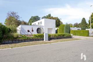 Top gelegen, moderne woning (327 m²) met 4 slaapkamers op een ruim perceel van 2253m².<br /><br />Deze royale en strakke villa is rustig gelegen op een steenworp van de Nederlandse grens. <br />Ze heeft een woonoppervlakte van 327 m² en is levensloopbestendig met een slaapkamer en badkamer op het gelijkvloers. <br />De grote raampartijen zorgen voor veel lichtinval alsook met de verbondenheid naar het terras en de tuin toe. <br />De groene tuin met de mooie bomen en waterpartijen is zeer onderhoudsvriendelijk en biedt een oase van rust. Verder is er aan de zijkant nog een kleine serre.<br /><br /><strong>INDELING:</strong><br /><strong>Gelijkvloers:</strong><br />Centraal: Inkomhal, leefruimte bestaande uit zithoek en gashaard en eethoek<br />De rechtervleugel heeft een ruime leefkeuken, bijkeuken met koele berging, zij-inkom, toilet, vestiaire, berging en garage met wma.<br />De linkervleugel bestaat uit een zeer ruime slaapkamer, nachthal met maatkasten en een badkamer met ligbad, douche en dubbele wastafel.<br /><strong>Verdieping:</strong><br />In de rechtervleugel zijn er op de verdieping drie grote slaapkamers en een badkamer. In één van de slaapkamers staat er een sauna.<br /><br /><strong>BIJZONDERHEDEN:</strong><br />- Géén renovatieplicht; label C;<br />- Elektra conform;<br />- levensloopbestendig;<br />- nabij Nederlandse grens;<br />- renovatiejaar circa 2000 en later.<br /><br /><strong>Bekijk zeker ook het filmpje! Uw bezoek meer dan waard!</strong>
