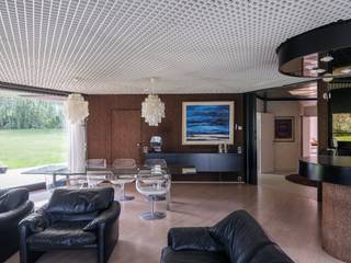 <strong>Oudenaarde</strong><strong> </strong><strong>– Architectenwoning van Guy Van Heuverswyn.</strong><br /><br /><span><span><span><span><span><u>Ruime jaren 70-bungalow, geïnspireerd op het <em>Case Study House Program</em>, met de mogelijkheid tot een combinatie van wonen en werken, een prachtige tuin en achterliggende landbouwgrond.</u></span></span></span></span></span><br /><br /><span><span><span><span><span><em>Voor meer informatie, mail naar info@carloeggermont.be.</em></span></span></span></span></span><br /><br /><span><span><span><span><span>Deze op te frissen architectenwoning met een bruto vloeroppervlakte van maar liefst 323 m² bevindt zich op een zeer bereikbare en zichtbare locatie, nabij de verbindingsweg N60 en het centrum van Oudenaarde.</span></span></span></span></span><br /><br /><span><span><span><span><span>De gunstige, alsook commerciële, ligging gecombineerd met de indeling van de woning, biedt uitstekende mogelijkheden voor een combinatie van wonen en werken.</span></span></span></span></span><br /><span><span><span><span><span>Deze bungalow wordt gekenmerkt door een efficiënte en modernistische bouwvisie, geïnspireerd op de principes van de <em>Case Study Houses</em>. Het grondplan is opgebouwd uit zeshoeken binnen een modulair bouwsysteem, wat zorgt voor een grote mate van flexibiliteit en tal van indelingsmogelijkheden.</span></span></span></span></span><br /><br />Zelfs voor de tuinberging werd dezelfde bouwwijze verdergezet om de uniformiteit te garanderen.<br /><br />Deze ruime woning bevindt zich op een prachtig perceel van maar liefst 2.412 m² en beschikt onder meer over drie slaapkamers, een voormalige bureauruimte met wachtkamer, een tekenkamer en een inpandige garage voor twee wagens.<br /><br />We betreden de woning langs een unieke inkomhal de woning opdeelt in enerzijds het voormalige professionele deel en anderzijds het woongedeelte.<br />Deze hal geeft plaats aan een ruime bureau (potentieel slaapkamer) en aan de overzijde de wachtkamer. Achtergelegen vinden we de voormalige tekenkamer, die alsook kan ingericht worden als slaapkamer.<br /><br />Gekoppeld aan deze inkomhal hebben we een tweede hal die enerzijds licht brengt dankzij de dakkoepel maar die voor de verbindingen zorgt tussen de de verschillende ruimtes in de woning.<br /><br />Hieraan gekoppeld vinden we een bijzonder architecturale leefruimte met haard en bar en zicht op zowel de voor- als de achtertuin, omringd door groen. Naastgelegen hebben we de originele keuken, die vooruitstrevend was voor zijn tijd.<br /><br />Een ruime hal met op maat gemaakte kasten leidt ons naar 3 slaapkamers, 2 badkamers waaronder 1 met een sauna, toegang tot de wasplaats, toegang tot de kelder en als laatste naar een dubbele inpandige garage.<br /><br />Als extra troef bestaat de mogelijkheid om de achterliggende landbouwgrond van 3.238 m² aan te kopen.<br /><br /><span><span><span><span><span><strong>Kortom, een bijzondere opportuniteit voor liefhebbers van architectuur.</strong></span></span></span></span></span><br />