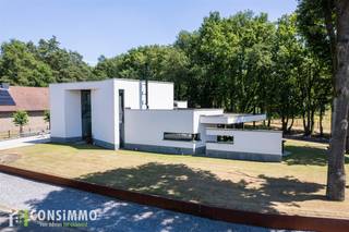 Bent u op zoek naar een moderne, instapklare villa met tijdloze architectuur, hoogwaardige afwerking en veel natuurlijk licht? Deze bijzondere woning aan de Neerzijstraat 28, gelegen in het gegeerde Bret-Gelieren, combineert rust, comfort en een toplocatie vlak bij alle voorzieningen.<br /><br /><strong>Indeling:</strong><br />Bij het binnenkomen via de royale inkomhal met vide en grote glaspartijen wordt meteen de toon gezet: licht, ruimte en verfijning voeren hier de boventoon. Vanuit de inkomhal bereikt u de elegante leefruimte, de open keuken, het gastentoilet en de trap naar de verdieping. De leefruimte is onderverdeeld in een gezellige zit- en eetkamer met zowel een gashaard als een houthaard – ideaal om een warme, huiselijke sfeer te creëren. De keuken is volledig ingericht met kwalitatieve inbouwtoestellen en grenst aan een handige berging en wasplaats met directe toegang tot de kelder. Deze kelder biedt extra opslagruimte, mogelijkheden voor hobby’s en plaats voor twee wagens in de inpandige garage.<br />Daarnaast bevindt zich op het gelijkvloers een afzonderlijke bureauruimte, perfect voor wie van thuis uit werkt of een aparte werkplek wenst.<br />Op de verdieping leidt de traphal met glazen wanden naar drie ruime slaapkamers en een badkamer. De master bedroom beschikt over een dressing, een privéterras en een ensuite badkamer met haard, inloopdouche, hoekbad, dubbele wastafel en toilet.<br /><br /><strong>Buitenruimte:</strong><br />De aangelegde tuin met overdekt terras en sfeervolle buitenhaard vormt een heerlijke plek om het hele jaar door te genieten in alle rust.<br /><br /><strong>Technische info:</strong><br />Deze architecturale villa is voorzien van aluminium ramen met driedubbele beglazing en behaalt een gunstig EPC-label B (115 kWh/m²). Verwarming gebeurt via vloerverwarming, een gashaard en een houthaard. De elektrische keuring is conform. Met een bewoonbare oppervlakte van 252 m² en een perceel van 8a 87ca geniet u hier van ruimte, comfort en kwaliteit.<br /><br /><strong>Ligging:</strong><br />De woning is gelegen in het exclusieve, groene Bret-Gelieren, een van de meest gewaardeerde wijken van Genk. U woont hier in een rustige, residentiële omgeving omgeven door natuur, met toch een vlotte verbinding naar het stadscentrum en de belangrijkste invalswegen. Scholen, winkels, openbaar vervoer en recreatiemogelijkheden bevinden zich op wandel- of fietsafstand. De buurt straalt klasse en toekomstwaarde uit, waardoor dit niet enkel een thuis is, maar ook een duurzame investering.<br /><br />Wordt deze moderne designvilla uw nieuwe thuis? Wacht niet langer en plan een bezoek via 089 69 30 01 of mail naar info@consimmo.be. Bekijk zeker ook de virtuele rondleiding op www.consimmo.be.