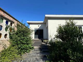 Deze mooie statige woning op een commerciële locatie biedt verrassend veel mogelijkheden. Omwille van het hoekperceel is de woning zowel via de Gentseweg als de Staakmolenstraat bereikbaar. De woning bestaat uit een woongedeelte, 3 slaapkamers, ruime lichtrijke leefruimte en keuken, statige inkom en zonneterras. Het geheel is volledig onderkelderd en voorzien van een grote garage. Aansluitend is er een recente en volledige studio, dewelke kan dienen als extra woonst maar tevens uitermate geschikt is voor een praktijk of burelen. Ook dit deel beschikt over een badkamer, keuken, leefruimte en 2 slaapkamers. Het grote voordeel is dat beide entiteiten in elkaar overlopen maar toch gescheiden zijn qua ingang. Tevens heeft elk woongedeelte een eigen vernieuwde CV ketel en aparte elektriciteitskast. De grote tuin zorgt voor de nodige privacy en rust en is voorzien van verschillende zonneterrassen. <br /><br />Echt een bezoekje waard !<br /><br />De villa wordt aangeboden met een richtprijs van 475.000€