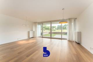 Op een toplocatie, op wandelafstand van Bredene-aan-Zee, bevindt zich dit prachtig afgewerkte gelijkvloerse appartement. Hier geniet u van de perfecte combinatie van rust en bereikbaarheid, met winkels, gezellige horecazaken, de zee én de uitgestrekte duinen binnen handbereik.<br />Een absolute troef is het ruime voorterras, waar u in alle rust kunt genieten van een weids, open zicht op de duinen. Dit unieke uitzicht zorgt elke dag opnieuw voor een heerlijk vakantiegevoel.<br /><br />Dankzij de ligging op het gelijkvloers is het appartement bijzonder vlot toegankelijk. Bovendien werd het met veel zorg afgewerkt, waarbij gekozen werd voor kwalitatieve materialen, een stijlvolle uitstraling en talrijke praktische inbouwkasten.<br /><br />De lichtrijke leefruimte vormt het hart van de woning. De grote raampartijen zorgen voor een aangename lichtinval en creëren een ruimtelijk gevoel. Hier vindt u voldoende plaats voor een gezellige zithoek en een ruime eetplaats, met directe toegang tot het zonnige voorterras en het prachtige uitzicht op de duinen.<br /><br />De open keuken sluit naadloos aan op de leefruimte en is volledig uitgerust met kwalitatieve toestellen en veel kastruimte, ideaal voor wie comfort en functionaliteit weet te waarderen.<br /><br />De moderne badkamer beschikt over een stijlvolle inloopdouche en een lavabo.<br /><br />Achteraan bevinden zich twee volwaardige slaapkamers, beide met toegang tot een tweede, rustig gelegen terras. Dankzij de terrassen aan zowel de voor- als achterzijde kunt u op elk moment van de dag genieten van zon of schaduw, volledig naar wens.<br /><br />Verder beschikt het appartement over een praktische berging met aansluiting voor wasmachine en droogkast.<br /><br />Als extra is er de mogelijkheid om een garagebox aan te kopen voor € 32.000. Daarnaast zijn er een gemeenschappelijke fietsenberging en afvalberging aanwezig.<br /><br />Kortom, een instapklaar appartement op een uitstekende ligging, met een hoogwaardige afwerking, twee zonnige terrassen én een open zicht op de duinen.