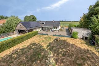 Dit mooi landhuis met verwarmd zwembad en poolhouse is verrassend ruim ingedeeld. Extra praktisch zijn de grote carport en de dubbele garage met vliering. <br />Het bijzonder gunstige EPC (B-label), de goedgekeurde elektra, zonnepanelen,... zijn maar enkele van de vele troeven van deze landelijke woning. Het huis is omringd door veel groen en het naastgelegen bosperceeltje van ruim 50 are is ook inbegrepen. <br /><br />=> Ligging<br />Gelegen in het landelijke Molenbeersel vlakbij de Nederlandse grens, waar rust, natuur en ruimte centraal staan. Je geniet hier van een groene woonomgeving met tal van wandel- en fietsmogelijkheden, terwijl andere voorzieningen zich op korte afstand bevinden. Dankzij de vlotte verbinding naar Maaseik, Bree en Nederland is dit een ideale locatie voor wie rustig wil wonen zonder in te boeten aan bereikbaarheid. <br /><br />=> Gelijkvloers <br />- Inkomhal/gang met toegang tot de verschillende ruimtes<br />- Luchtige L-vormige woonkamer met mooie parketvloer<br />- Doorzonkamer met vrij uitzicht over de weilanden aan de overzijde<br />- Gezellige inbouwhaard die op frisse avonden voor een warme sfeer zorgt<br />- Open keuken, voorzien van veel kastruimte en alle denkbaar comfort<br />- De leefkeuken ligt centraal tussen de woonkamer en de zonnige tuinkamer aan de achterzijde<br />- Tuinkamer/veranda met zicht op en toegang tot buiten<br />- Grote tussenruimte met veel lichtinval en toegang naar zowel de praktische wasplaats als naar de tuin<br />- Deze ruimte kan naar wens ingericht worden maar biedt veel mogelijkheden<br />- Ouderlijke slaapkamer met airco<br />- Rechtstreeks toegang naar de ingerichte dressing vanuit deze slaapkamer<br />- Complete badkamer voorzien van grote inloopdouche en dubbele wastafel in landelijk meubel<br />- De badkamer is eveneens voorzien van toilet en bidet en heeft vloerverwarming<br />- Bureel/kleine slaapkamer <br /><br />=> Verdieping<br />- Via de overloop met extra opbergruimte is er toegang tot de twee grote slaapkamers boven en het toilet<br />- Slaapkamer met inbouwkasten in zijwanden<br />- Tweede slaapkamer/hobbyruimte voorzien van airco en zicht over de tuin<br /><br />=> Tuin<br />- Fantastisch overdekt terras met zicht over het verwarmd zwembad met nieuw roldek<br />- Terras met praktische buitenkeuken<br />- Genieten van vakantie aan huis kan hier in alle privacy<br />- Zowel links als rechts van het huis is er nog een groot stuk tuin waardoor er een enorm gevoel van vrijheid is<br />- Volledig omheind terrein<br />- Nieuwe grote dubbele carport<br />- Tevens een dubbele inpandige garage met grote vliering erboven<br />- De grote achtertuin is ideaal voor spelende kinderen, huisdieren of gewoon voor iedereen die houdt van veel groen rondom<br />- Het bosperceel van ruim 50 are links van de woning is eveneens inbegrepen<br /><br />=> Indeling<br />-- Gelijkvloers: centrale hal, L-vormige woonkamer, leefkeuken, tuinkamer/veranda, nachtgang, ouderlijke slaapkamer met eigen dressing, bureel/kleine slaapkamer, badkamer met toilet, wasplaats, grote tussenruimte en dubbele garage met vliering;<br />-- Verdieping: overloop met bergruimte, toilet en twee grote slaapkamers/hobbyruimtes;<br />-- Poolhouse en verwarmd zwembad;<br />-- Grote dubbele carport