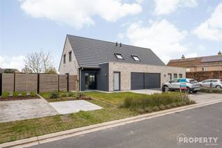 Indeling: inkomhal met gastentoilet, open leefruimte met inbouwhaard, open keuken met keukeneiland en voorzien van alle toestellen. Ruime garage.Op...