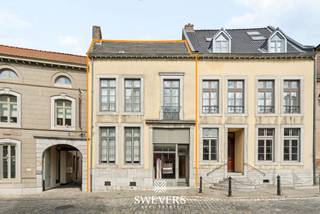 Voor meer info en foto’s, surf naar www.swevers.be – Aan Markt 1 in Tongeren-Borgloon bevindt zich dit karaktervolle herenhuis met maar liefst 346 m² bewoonbare oppervlakte. De woning dateert van voor 1850, kende tussen 2009 en 2013 reeds een grondige restauratiefase en biedt vandaag volop mogelijkheden voor een verdere renovatie naar eigen smaak. Op het gelijkvloers vind je ruime leefvertrekken met onder meer een living van 41,20 m², eetkamer van 13,32 m², keuken van 12,08 m² en berging. In totaal beschikt de woning over zes slaapkamers en drie wc’s, ideaal voor een groot gezin of wie extra kamers wenst voor thuiswerk, hobby’s of gasten. Ook aan bergruimte is er geen gebrek. De kelder meet 60,24 m² en de uitzonderlijk ruime zolder maar liefst 136 m², wat bijkomende mogelijkheden biedt mits de nodige vergunningen en technische haalbaarheid. Het perceel van 6 are omvat een noordelijk georiënteerde tuin en een garage. De centrale ligging is een extra troef: winkels, scholen, horeca, ontspanning en openbaar vervoer bevinden zich op korte afstand. Ook de fruitboomgaarden en het bekende doorkijkkerkje liggen vlakbij. Een bijzonder renovatieproject voor wie ruimte, karakter en een centrale ligging wil combineren.Voor meer informatie, bel 012 699 900. Bron bewoonbare oppervlakte: EPC –verslag. Dit pand is onderworpen aan de renovatieverplichting van de Vlaamse overheid voor residentiële gebouwen (behoudens bij sloop binnen 5 jaar na de aankoop). Consulteer voor meer informatie de website van het Vlaams Energie- en Klimaatagentschap via https://www.vlaanderen.be/een-huis-of-appartement-kopen/renovatieverplichting-voor-residentiele-gebouwen.
