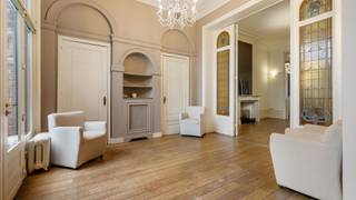Bij het betreden van deze statige woning naar de hand van architect Jules Taeymans word je meteen verwelkomd in een indrukwekkende inkomhal die naadloos overgaat in een karaktervolle traphal. Op deze verdieping bevinden zich een recent vernieuwde keuken (Interieurstudio Hoskens), een sfeervol salon met hoge plafonds en verfijnde ornamenten, een ruime eetkamer en een lichtrijke tuinkamer die uitkijkt op de tuin.<br /><br />Daarnaast is er een polyvalente hobby- of kantoorruimte met apart sanitair en sauna, rechtstreeks toegankelijk via de inkomhal – ideaal voor ontspanning of professioneel gebruik. Aansluitend vind je de technische ruimte met o.a. de omvormer van de zonnepanelen en de centrale verwarming.<br /><br />Buiten geniet je van een zonnig terras, een gezellige stadstuin en rechtstreekse toegang tot de dubbele garage.<br /><br />Op de verdiepingen bevinden zich maar liefst 7 volwaardige slaapkamers met houten vloeren en 2 badkamers. Deze woning leent zich perfect voor grote gezinnen, co-housing, een combinatie van wonen en werken, of voor wie ruim en comfortabel in het hart van de stad wil wonen.<br /><br />Deze unieke herenwoning biedt uitzonderlijk veel mogelijkheden, zowel voor privébewoning als voor de inrichting van een kantoor of praktijkruimte.<br /><br />Buitengewone troeven:<br />* Tijdloze architectuur gecombineerd met hedendaags comfort, inclusief een dubbele garage met uitrit naar de Molenstraat – een absolute meerwaarde in deze buurt<br />* Energiezuinig dankzij zonnepanelen (2010), conforme elektrische keuring en quasi asbestvrij (enkel één radiatorknop in een slaapkamer)<br />* Centrale ligging nabij winkels, horeca en openbaar vervoer