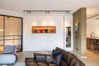 Sublimely finished ground floor design apartment, fully developed and realized by Huis Creemers, located in the historic heart of Tongeren.<br /><br />Sale under registration fees. No VAT!<br /><br />The apartment is part of the enclosed Residence 'Ilex', surrounded by a beautifully landscaped, mature garden. You live within walking distance of the center of Tongeren, with all amenities within reach.<br /><br />This recent apartment (built in 2020) offers a generous living area of 165 m² and has a beautiful southwest-facing terrace of 32 m². The interior concept is consistently carried through in every space, with a refined harmony between walnut wood, lacquer, and natural stone.<br /><br />The light-filled living space is equipped with custom-made cabinets, discreet integrated techniques, and a cozy gas fireplace, creating a sleek yet warm overall look.<br /><br />Central in the apartment is a generous kitchen island in quartzite natural stone. The kitchen is equipped with high-quality appliances, including a BORA hob, Siemens oven with steam function, Quooker tap, Liebherr fridge with ice cube function, and a built-in wine climate cabinet.<br /><br />The spacious bathroom combines aesthetics and functionality and is finished with custom-made Corian, a Whirlpool bath, walk-in shower, and high-quality Japanese toilet installation.<br /><br />Furthermore, the apartment has two bedrooms, one of which is currently furnished as an office or guest room. The master bedroom includes a stylish integrated built-in dressing room. A practical laundry room/storage room is discreetly integrated into the overall concept.<br /><br />On a technical level, this apartment is fully equipped for the future with an advanced home automation system, alarm system, and camera surveillance. With an energy performance level of E45 (77 kWh/m²·year) and energy label A, the property combines luxurious living comfort with excellent energy efficiency.<br /><br />The whole is completed by an additional parking space within the secure residence. For an additional fee, a very spacious private garage box can be purchased. An exceptional living opportunity for those who want to combine design, comfort, and tranquility in a prime location.