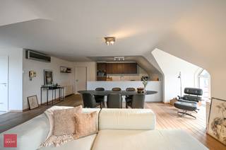 In nabijheid van winkels, supermarkt, station...<br /><br />Uiterst gezellig en vernieuwd dakappartement (170m²) bestaande uit inkom met vestiaire, berging en toilet. Twee slaapkamers met ingemaakte kasten, dressing, badkamer, open keuken, bureau (of extra slaapkamer), zonneterras met zicht op de rustige Wolvenstraat, autostaanplaats inbegrepen. Airco aanwezig in living en slaapkamer. Overal parket.