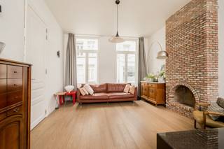 <p><strong>Quares - TREVI Groep presenteert :<br />Prachtige interbellum herenwoning met tuin en garage (vrij beroep mogelijk)</strong></p>
<p>Deze prachtige herenwoning uit het interbellum werd totaal gerenoveerd in 2018. Hierbij werd er gewerkt met kwalitatieve en hoogwaardige materialen alsook werd er rekening gehouden met een optimale indeling van de ruimtes. Een enorm ruimtegevoel werd gecreëerd door grote raampartijen, een goede vormgeving en de juiste oriëntatie waarbij het behoud van authentieke elementen centraal staat. De uitzonderlijk gevelbreedte (+/- 13m) voor een woning in de binnenstad zorgt voor veel daglicht in de ruimtes, zowel op het gelijkvloers als op de verdiepingen.</p>
<p>Bij het betreden van het pand krijg je een instant wauw-gevoel door de hoge plafonds, tegel- en houtvloeren in combinatie met modern comfort en warme materialen. De leef- en eetruimte zijn volledig opengetrokken waarbij je een directe connectie ervaart met de achterliggende tuin. De houthaard zorgt voor extra sfeer en gezelligheid. De semi-open keuken bevindt zich in een L-vorm met de leef-en eetruimte. Hierdoor is de leefkeuken het centrale hart van de woning waar je een leuke interactie kan ervaren tussen koken, aperitieven, gezelligheid en wederom dezelfde connectie met de achterliggende tuin. Door de grote schuiframen kan je een binnen/buiten gevoel creëren waarbij bij zonnig weer deze ruimtes naadloos in elkaar overlopen. De keuken is volledig uitgerust met kasten en toestellen en beschikt naast voldoende opbergruimte over voldoende werkruimte voor de hobbykok. Naast de keuken bevindt zich nog een ruime bergruimte.</p>
<p>Vooraan aan de woning is er een afzonderlijke bureauruimte voorzien, ideaal voor thuiswerk, maar geeft ook opportuniteiten voor vrije beroepen. <br />Verder is er nog een ruime inkomhal met afzonderlijk gastentoilet en ruimte voor vestiaire. <br /><br />Via de trap kan je naar de eerste verdieping. Hier bevinden zich de masterbedroom met dressingruimte. Verder zijn er nog twee zeer ruime slaapkamers, alsook een prachtige badkamer uitgerust met dubbele lavabo, ligbad, en inloopdouche. Er is tevens een afzonderlijk toilet.</p>
<p>Op de tweede verdieping bevinden zich nog een polyvalente ruimte, volledig onder een prachtig houten dakgebinte, dat naar wens kan worden ingericht. Denk aan extra slaapkamers, hobbyruimte, extra kantoorruimte,.. . Hier zijn tevens aansluitingen voorzien voor een tweede badkamer.</p>
<p>De tuin met terras is volledig aangekleed en gezellig ingericht, ideaal om te ontspannen. Er is zowel een zijingang voorzien alsook een toegang naar de overdekte staanplaats die gekoppeld is aan het perceel (toegang via Lange Nieuwstraat). De garage is naast autostalplaats ideaal als fietsenberging en opbergruimte.</p>
<p>Deze woning is ideaal voor mensen die van ruimte en modern comfort houden en de aanwezigheid van zeer veel natuurlijk daglicht in hun woning cruciaal vinden. Daarnaast heeft de woning een zeer laag E-peil en zorgt doorgedreven isolatie aan de binnenzijde voor een aangenaam binnenklimaat. Domoticasysteem bedienbaar via app aanwezig.</p>
<p>De zolder zorgt ervoor dat de koper nog een eigen toets kan aanbrengen aan het pand. <br /><br /></p>
<p>Verder is er nog een ruime, droge kelder met vrije hoogte die extra veel opbergruimte biedt. Er is een regenwaterinstallatie die volledig werd vernieuwd in 2026 waardoor de toiletten, buitenkraan en een kraantje voor poetswater in de bergruimte op regenwater werken (uitbreiding mogelijk naar wasmachine).</p>
<p><br />De woning situeert zich in het hart van de stad, op wandelafstand van openbaar vervoer, winkels, sportfaciliteiten, allen op wandel-/fietsafstand.<br /><br />Laat deze unieke kans niet voorbij gaan.</p>