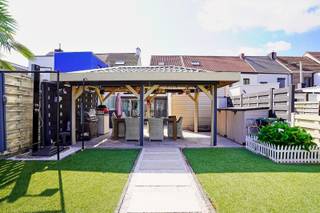 <p>Bij het betreden van deze woning komt u binnen in een verzorgde inkomhal die toegang biedt tot de verschillende leefruimtes. De bijzonder ruime en lichtrijke leefruimte sluit naadloos aan op de grote keuken, die geniet van een aangenaam zicht op de tuin. Hierdoor vormt de keuken de ideale plek om te koken en tegelijk van het buitengevoel te genieten.<br />De woning beschikt over een ruime badkamer, uitgerust met zowel een ligbad als een douche, wat zorgt voor optimaal comfort. Verder zijn er drie volwaardige slaapkamers, ideaal voor een gezin of om een extra bureau- of hobbyruimte in te richten.<br />Praktische bergruimte is er eveneens voldoende dankzij de aanwezige kelder en het tuinhuis. Daarnaast beschikt de woning over een garage die niet alleen plaats biedt voor fietsen, maar ook ingericht is als handige wasruimte.<br />Kortom, deze woning combineert ruime leefvolumes, praktische voorzieningen en een aangename tuin, waardoor ze de ideale thuis vormt voor wie op zoek is naar comfort en functionaliteit.<br />Referentie: 5696</p>
