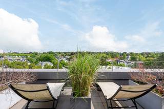 <div>
<section>
<div>
<div>
<div>
<div>
<div>
<div>
<h3>Penthouse d’exception avec 200 m² de terrasses</h3>
<p>Situé dans l’un des quartiers les plus recherchés du sud d’Anvers, à proximité de plusieurs parcs, ce penthouse exceptionnel a été entièrement rénové en 2022-2023. Il séduit par ses finitions haut de gamme, sa luminosité et son confort de vie.</p>
<p>Le vaste séjour sur parquet bénéficie d’une abondante lumière naturelle grâce à ses grandes baies vitrées et s’ouvre sur une élégante cuisine ouverte. Celle-ci est réalisée en travertin, équipée d’un système Aqualex et d’électroménagers de qualité. Son îlot central constitue le cœur de l’espace de vie.</p>
<p>Le séjour donne accès aux terrasses entourant entièrement l’appartement, pour une superficie totale d’environ 200 m². Elles offrent intimité, vues dégagées et excellente orientation. Un sauna privé complète cet espace extérieur unique.</p>
<p>L’appartement dispose également d’un bureau ou salon TV avec mobilier sur mesure en noyer, d’une buanderie, de deux chambres spacieuses et de deux salles de bains en suite. La suite parentale bénéficie de dressings sur mesure avec une élégante finition en suède.</p>
<p>Un penthouse clé en main offrant de vastes espaces extérieurs, des finitions de qualité et une adresse privilégiée dans le sud verdoyant d’Anvers.</p>
</div>
</div>
</div>
</div>
</div>
</div>
</section>
</div>