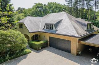<p><span>! OPEN HUIS - WOENSDAG 14 OKTOBER VAN 15U TOT 18U ! </span></p><p><span>Residentieel gelegen villa op een privacyrijk perceel van 2.672 m², tegenover een natuurgebied en nabij het centrum van Heide-Kalmthout, met o.a. een ruime en lichtrijke leefruimte, leefkeuken, vijf royale slaapkamers, drie ingerichte badkamers en een wellnessruimte met binnenzwembad en sauna. </span></p><p><span>INDELING</span></p><p><span>Gelijkvloers</span></p><p><span>U betreedt de woning via een ruime inkomhal op natuurstenen vloer, voorzien van een gastentoilet met handenwasser en een vestiaire. Deze hal geeft toegang tot de royale en lichtrijke leefruimte op parketvloer, onderverdeeld in een tv-hoek, een zithoek met erker en gashaard en een eetruimte.</span></p><p><span>Aansluitend bevindt zich de volledig uitgeruste leefkeuken met alle hedendaagse toestellen, waaronder een combi-oven, microgolf, inductievuur met ingebouwde dampkap, spoelbak met Quooker-kraan, een grote koelkast, een vriezer en een vaatwasser. De ontbijthoek biedt directe toegang tot het overdekte terras met uitzicht op de prachtig aangelegde tuin.</span></p><p><span>Daarnaast beschikt het gelijkvloers over een masterbedroom op laminaatvloer met aansluitend een dressing en een ingerichte badkamer. Deze is uitgerust met een inloopdouche voorzien van een infrarood Sunshower, een ligbad, dubbele wastafel, toilet en handdoekenradiator.</span></p><p><span>Ten slotte is er nog een dubbele inpandige garage met automatische poort, waar zich eveneens de aansluitingen voor wasmachine en droogkast bevinden.</span></p><p><span> </span></p><p><span>Eerste</span><span> </span><span>verdieping</span></p><p><span>Via de royale trap met vide bereikt u de nachthal, waar zich een apart toilet en een bergkast bevinden. Bovendien heeft u toegang tot een knus balkon. Op deze verdieping bevinden zich vier zeer ruime slaapkamers en een tweede badkamer, ingericht met een douche, ligbad, wastafel, toilet en handdoekenradiator.</span></p><p><span> </span></p><p><span>Zolder</span></p><p><span>Via een vlizotrap heeft u toegang tot de bergzolder.</span></p><p><span> </span></p><p><span>Kelder</span></p><p><span>Middels de centrale trappartij bereikt u de kelder, opgedeeld in drie compartimenten: een bergruimte, een technische ruimte en een ontspanningsruimte. Deze laatste is uitgerust met een zwembad (4 m x 9 m) met jetstream, een traditionele sauna en een badkamer voorzien van een douche, wastafel en toilet. Via een schuifdeur heeft u toegang tot een aangenaam omsloten terras.</span></p><p><span> </span></p><p><span>Tuin</span></p><p><span>De woning is gelegen op een volledig omheind perceel van ca. 2.650 m². De prachtig aangelegde tuin die volledige privacy biedt en veel zoninval geniet, is voorzien van een irrigatiesysteem en meerdere vijverpartijen, die bijdragen aan een rustgevende en groene leefomgeving.</span></p><p><span>Bijzonderheden</span><span><br />-Charmante villa in klassieke/tijdloze stijl <br />-Recent gemoderniseerd o.a. keuken, badkamers, vloeren, …. <br />-Verrassend ruim<br />-Volledige privacy <br />-Fraai aangelegde en goed onderhouden tuin met veel zoninval<br />-Zuid-west georiënteerd<br />-Goed beveiligd<br />-Binnenzwembad en sauna in de kelder met buitenterras<br />-Rustig in het groen gelegen, tegenover natuurgebied en nabij dorpscentrum (scholen, winkels en openbaar vervoer). <br />-Elektrische keuring is conform.<br />-Geen asbest</span></p><p><span> </span></p>