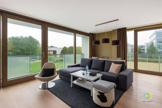 <p><span>Met zicht op het groene domein Drie Fonteinen bevindt zich dit lichtrijke appartement op de eerste verdieping van een modern gebouw met lift. U betreedt het gebouw via een monumentale inkomhal. Het appartement is praktisch ingedeeld met een duidelijk onderscheid tussen het leef- en het slaapgedeelte, gescheiden door de hal. De leefruimte vormt één geheel met de open ingerichte keuken, voorzien van alle comfort. Naast de keuken bevindt zich een berging met aansluiting voor een wasmachine. Dankzij ramen aan verschillende zijden geniet u de hele dag door van een aangename natuurlijke lichtinval. Via het grote schuifraam heeft u toegang tot het terras. Het slaapgedeelte omvat twee slaapkamers, een badkamer met ligbad en dubbele wastafel, een doucheruimte met wastafel en een aparte toilet. Het appartement beschikt over een uitstekende EPC-score en een conforme elektrische installatie. Het appartement is momenteel verhuurd, wat het niet alleen interessant maakt voor wie op zoek is naar een aangename woonst in een groene omgeving, maar ook voor investeerders die wensen te genieten van een onmiddellijk rendement.</span><span> </span><span>Een staanplaats onderaan het gebouw is verplicht bij aan te kopen (€15.000). </span></p>