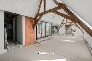 In het historische centrum van Brugge ligt Karmel, een bijzonder woonproject op de voormalige site van het Karmelklooster. Het historische karakter van het gebouw werd behouden en gecombineerd met hedendaags wooncomfort. Zo woon je op een rustige, groene plek in de binnenstad, op wandelafstand van alles wat Brugge te bieden heeft.<br /><br />Appartement A2.3 is een ruim triplexpenthouse met een bewoonbare oppervlakte van 241 m². Het appartement beschikt over 3 slaapkamers, 2 badkamers, een ruime leefruimte met vide, wat zorgt voor veel lichtinval, halfopen keuken. Het leuke effect van de ingebouwde patio (12m²) zorgt voor lichtrijk zongevoel in de leefruimte. <br /><br />De absolute troef bevindt zich op het derde niveau: een dakterras van 30m² met een uitzonderlijk 360°-zicht over de Brugse skyline. Dit ruime terras wordt dan ook nog eens begrensd met mooie groenzones. Een unieke buitenruimte die het appartement een bijzonder karakter geeft.<br /><br />Dit appartement heeft dus heel wat buitenruimte te bieden op dé stilteplek in Brugge. Ideaal voor wie rust in de stad zoekt. <br /><br />De grootste werken zijn intussen achter de rug. Als koper krijg je nog de ruimte om de laatste afwerkingskeuzes zelf te maken en het appartement zo verder vorm te geven volgens je eigen stijl.<br /><br />Ook op het vlak van duurzaamheid werd Karmel toekomstgericht uitgewerkt. Ook technisch is het appartement bijzonder compleet uitgerust, met geothermische verwarming en koeling, vloerverwarming, ventilatiesysteem D met warmterecuperatie, zonnepanelen en regenwaterrecuperatie. De hoogwaardige basisafwerking omvat onder meer eiken parket, uitgeruste badkamers en een keuken met natuurstenen werkblad en toestellen. De laatste materiaal- en interieurkeuzes kan je als koper nog mee bepalen.<br /><br />Karmel combineert zo een unieke historische locatie met rust, ruimte en modern wooncomfort, midden in het centrum van Brugge.<br /><br />Wil je dit bijzondere appartement en de site zelf ontdekken? Contacteer ons voor een bezoek ter plaatse via 050 45 03 45 of info@delbecque.immo.