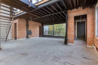 Dit eigendom biedt een casco af te werken loftwoning, gelegen op een vlot bereikbare locatie in Kruibeke. De woning wordt afzonderlijk aangeboden; een achterliggend magazijn kan optioneel worden bijgekocht.<br /><br />De woning bevindt zich in casco winddichte staat en dient verder te worden afgewerkt conform de geldende omgevingsvergunning. De vergunde plannen voorzien in een ruime ééngezinswoning met focus op licht, privacy en wooncomfort. Een combinatie van wonen en werken behoort tot de mogelijkheden, onder voorbehoud van eventuele functiewijziging.<br /><br /><strong>Technische uitvoering & isolatie (woning):</strong><br />Geïsoleerde gevels en dak, met geplaatste ramen en deuren voorzien van isolerend en zonwerend glas aan de zuidzijde.<br /><br /><strong>Indeling:<br /></strong>Op het gelijkvloers is er een inkomhal met vestiaire en gastentoilet. De woning is georganiseerd rond een centrale patio van ca. 31 m². Verder zijn er drie slaapkamers, een badkamer en een berging. Aan de achterzijde bevindt zich de leefruimte met eetplaats en keuken, gericht op de patio en buitenruimte.<br /><br />Op de verdieping voorziet de vergunning in een wintertuin van ca. 32,5 m² met aansluitend twee terrassen (ca. 19 m² en 20 m²). De vide zorgt voor extra licht en ruimtelijkheid.<br /><br /><strong>Buitenruimtes:</strong><br />De patio en terrassen bieden aangename en private buitenruimtes. Parkeermogelijkheid is voorzien op het perceel.<br /><br /><strong>Bijzonderheden:</strong><br />Casco af te werken loftwoning in winddichte staat.<br />Optioneel magazijn beschikbaar bij aankoop.<br /><br /><strong>Ligging:</strong><br />Gelegen in de Bazelstraat te Kruibeke. Vlotte bereikbaarheid richting Antwerpen en het Waasland.