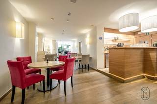 <p>Local commercial bien situé avec terrasse et double habitation. Établissement horeca prospère et bien établi. Situé près de la basilique et à quelques pas du marché de Renaix. Aménagement : entrée avec vestiaire, espace commercial avec grand bar (lave-vaisselle, réfrigérateurs encastrés, machine à café italienne, système de caisse pour l'hôtellerie), véranda avec toit coulissant ouvert, pare-soleil et auvent, toilettes tendance, terrasse fermée avec parasols amovibles, grande cuisine professionnelle avec lave-vaisselle, chambre froide, grande cuisinière, salamandre, friteuse, trancheuse, 2 armoires chauffantes, îlot avec espace de rangement (bar à salades, frigos et tiroirs réfrigérés), four combiné, ... arrière-cuisine en inox. Tous les appareils sont inclus ! 3 grandes caves (boissons, aliments secs et buanderie) ! Permis des pompiers pour 49 personnes.  Aménagement du 1er logement : salon, 4 chambres, dressing, salle de bains et grenier ! Aménagement du 2e logement : au rez-de-chaussée : entrée, salon/bureau avec accès à une grande cave sèche avec accès séparé à la rue, premier étage : salon, chambre et salle de bains. Deuxième étage : grenier avec accès au toit (possibilité d'aménager une terrasse sur le toit), chambre. Le bâtiment commercial est prêt à emménager, les logements doivent être rafraîchis !</p>