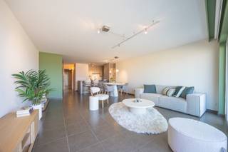 RESIDENTIE COMMODORE – EXCLUSIEF TWEE-SLAAPKAMERAPPARTEMENT OP DE ALBERT I PROMENADE<br />Dit stijlvol afgewerkte appartement is gelegen op de eerste verdieping van de prestigieuze Residentie Commodore, op de Albert I Promenade te Oostende.<br />De indeling omvat een inkomhal, een lichtrijke woonkamer met volledig ingerichte open keuken, een praktische berging en een afzonderlijk toilet. Verder zijn er twee slaapkamers, waarvan één met badkamer en suite en één met een eigen douchekamer.<br />Vanuit de woonkamer en het terras geniet u van een prachtig zicht op zee en de strekdam. Een individuele kelder is inbegrepen. Garagebox 53 in de residentie kan afzonderlijk worden aangekocht voor € 85.000.<br />• Opp.: 95 m² + 8 m² terras<br />• Prestigieuze residentie met geen grote werken gepland<br />• KI: € 1.293<br />• Individuele kelder inbegrepen en gemeenschappelijke fietsenberging aanwezig<br />• EPC: 117 kWh/m² jaar – Label B<br />• Mogelijkheid tot aankoop van garagebox 53: € 85.000