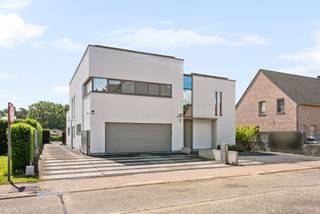 Cette villa moderne et économe en énergie (label EPC A) est située dans un environnement boisé à Oevel, Westerlo. Cette propriété date de 2009 et est finie avec des matériaux de qualité. La villa comprend un magnifique espace de vie avec coin salon, coin repas et cuisine ouverte équipée, buanderie, 4 chambres, 2 salles de bains, dressing, débarras, grand garage intégré pour 2 voitures, piscine et annexe multifonctionnelle.<br /><br />Rez-de-chaussée:<br />Vous entrez dans la maison par le hall d'entrée avec toilettes séparées. Le salon et la cuisine baignent dans la lumière naturelle grâce aux grandes baies vitrées à l'arrière de la maison. La cuisine moderne est entièrement équipée avec des appareils de haute qualité tels que micro-ondes, four vapeur, four, plaque à induction et lave-vaisselle, et dispose de nombreux espaces de rangement et d'un plan de travail en béton avec table à manger intégrée. À côté de la cuisine, on trouve un débarras pratique et une buanderie avec raccordement pour machine à laver et accès au double garage intégré.<br /><br />Premier étage:<br />La suite parentale est entièrement privative et se compose d'une grande chambre avec terrasse et vue sur le jardin et d'un dressing. Il y a également une salle de bains équipée avec douche à l'italienne, double lavabo et une grande baignoire. En outre, il y a trois chambres supplémentaires et une salle de douche séparée avec douche et meuble lavabo. Les toilettes sont séparées.<br /><br />Jardin:<br />Le jardin offre une belle vue à l'arrière et est entièrement clôturé. La piscine chauffée avec poolhouse/annexe complète l'ensemble. En toute saison, vous pourrez profiter ici de détente et de confort. L'annexe peut parfaitement être utilisée pour des professions libérales ou comme poolhouse. Actuellement, elle est aménagée en showroom.<br /><br />Particularités:<br />* Chauffage au sol<br />* Climatisation dans les chambres<br />* Alarme présente<br />* Annexe multifonctionnelle<br />* Logement économe en énergie<br />* Architecture particulière