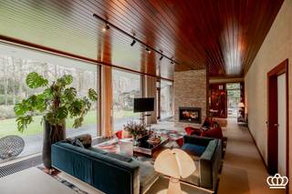 <p><span>Hippe seventies-villa in full retro vibe!</span></p><p><span> </span></p><p><span>Volledig in stijl gerenoveerd én ingericht—hier woon je gelijkvloers in pure 70’s sfeer, met een royale leefruimte vol gigantische raampartijen en heerlijk veel licht. Momenteel ingedeeld met 2 slaapkamers en 2 badkamers, een enorme zolderverdieping en een aansluitend bijgebouw met dubbele garage en atelier. Dit alles op een riant, zuidgericht perceel van ca. 4.700 m², in een rustige residentiële buurt vlak bij het centrum van Kapellen.</span></p><p><span> </span></p><p><span>Gelijkvloers</span></p><p><span>Binnenkomen doe je in een strakke inkomhal met gastentoilet. De leefruimte is één grote open, lichte cocon met uitzicht op het beukenbos. Dankzij de nieuwe doorkijkhaard ontstaat een cozy scheiding tussen zithoek en eetruimte. Aansluitend vind je de unieke, semi-open keuken—retro in look, modern in comfort.</span></p><p><span>De masterunit is pure luxe: een ruime slaapkamer met zicht op de tuin, volledig ingemaakte dressingkasten én een wellness-badkamer met sauna, ligbad, inloopdouche, toilet en dubbele lavabo. Daarnaast is er een aparte dressingruimte.</span></p><p><span>Aan de andere zijde van de inkom bevindt zich de tweede slaapkamer, eveneens met eigen inloopdouche en toegang tot een overdekt terras in de knusse binnentuin.</span></p><p><span> </span></p><p><span>Zolder</span></p><p><span>Via een vlizotrap kom je op een gigantische bergzolder over de volledige woning, met betonnen vloer. De centrale inkomhal biedt de mogelijkheid om een vaste trap te plaatsen—ideaal om deze etage om te toveren tot extra slaapkamers, hobbyruimte of home office.</span></p><p><span> </span></p><p><span>Bijgebouw</span></p><p><span>Het geschakelde bijgebouw (60 m2) herbergt een atelierruimte met aansluitingen voor de wasmachine en een dubbele garage.<br />Dit gebouw kan ook perfect dienen als kantoor, atelier of praktijkruimte aan huis.</span></p><p><span> </span></p><p><span>Tuin</span></p><p><span>Rondom de villa ligt een prachtige, zuidgerichte bostuin met volwassen beuken en veel privacy. Achteraan vind je een groot zonneterras. Tussen de woning en het bijgebouw vormt een afsluitende buitenmuur een sfeervolle binnentuin, een mediterrane patio vibe, maar dan in Kapellen.</span></p><p><span> </span></p><p><span>Bijzonderheden</span></p><p><span>- Originele 70’s villa, volledig in stijl opgefrist.</span></p><p><span>- De villa kenmerkt zicht door de grote raampartijen en de hoge plafondhoogte van meer dan 3 meter</span></p><p><span>- Topligging in een gegeerde residentiële wijk nabij het dorpscentrum.</span></p><p><span>- Zuidgerichte tuin met prachtige bomen.</span></p><p><span>- Grote zolderverdieping met talloze mogelijkheden.</span></p><p><span>- Gekoppeld bijgebouw, ideaal voor kantoor of praktijk aan huis<br />- Bewoonbaar oppervlakte van 278 m2 incl het bijgebouw (60 m2) en excl de zolder (ca. 160 m2).</span></p><p><span>- De living werd onder toezicht van de architect ingericht en mogelijk om mee aan te kopen. </span></p><p><span> </span></p><p><span> </span></p>