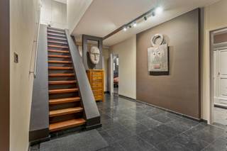 <p>Moderne, vrijstaande villa met een riante leefruimte, kantoor en prachtige tuin.</p>
<p>In een residentiële en rustige omgeving bevindt zich deze mooie, moderne vrijstaande villa, gelegen op een royaal perceel van 2.004 m² met een straatbreedte van circa 42 meter. De woning onderscheidt zich door haar ruime indeling, grote glaspartijen, duurzame materialen en veelzijdige gebruiksmogelijkheden. Dankzij de uitzonderlijk ruime bureelruimte is deze villa bijzonder geschikt voor wie comfortabel van thuis uit wil werken of een vrij beroep wenst uit te oefenen.</p>
<p>Op het gelijkvloers verwelkomt u een ruime inkomhal met Belgische blauwsteen als vloerbekleding. Links bevindt zich de trap naar de bovenverdieping en het gastentoilet met handenwasser. Achteraan bevindt zich een ruime kamer, momenteel ingericht als dressing, die de mogelijkheid biedt om een bijkomende slaapkamer te creëren. De badkamer is uitgerust met een douche en lavabomeubel. Naast de badkamer bevindt zich de slaapkamer met ingemaakte kasten en aansluitend een douchecel en lavabo. Verder zijn er nog een praktische wasplaats, een berging met de verwarmingsinstallatie, van hieruit heeft u toegang naar buiten en een inpandige garage met carport.</p>
<p>De eerste verdieping vormt het hart van de woning en biedt een bijzonder ruime en lichtrijke leefruimte, harmonieus ingedeeld in een eetplaats en een gezellige zithoek met haard. De massieve eikenhouten parket van 22 mm dik en de hoge glaspartijen over de volledige lengte zorgen voor een warme, moderne uitstraling en een overvloed aan natuurlijk licht.</p>
<p>Via een dubbele schuifdeur bereikt u het ruime terras van ongeveer 30m², afgewerkt met bankirai planken en voorzien van verlichting, een elektrisch bediende zonneluifel en een riante ijzeren draaitrap die rechtstreeks toegang geeft tot de tuin. De open keuken sluit naadloos aan op de leefruimte en geniet van een mooi uitzicht op het groen. Ze is uitgerust met boven- en onderkasten, een koelkast, oven, vaatwasser, kookplaat met geïntegreerde afzuiging en spoelbak met aansluitend de berging/bijkeuken en aparte toiletruimte.</p>
<p>Aan de linkerzijde van de woning bevindt zich een uitzonderlijk ruime bureelruimte van circa 50m². De massieve eikenhouten parket van 22 mm dik, de talrijke hoge glaspartijen en het panoramische uitzicht over de tuin en de omgeving creëren een inspirerende werkomgeving. De ruimte beschikt bovendien over een elektrische zonneluifel en airco. Deze polyvalente ruimte biedt tal van mogelijkheden voor thuiswerk, een kantoor aan huis of de uitoefening van een vrij beroep of masterbedroom.</p>
<p>Op de tweede verdieping bevindt zich een zolderruimte van circa 90 m² die nog verder afgewerkt kan worden. Hierdoor beschikt de woning over bijkomend potentieel voor uiteenlopende invullingen, afhankelijk van uw wensen en behoeften.</p>
<p>Ook buiten heeft deze villa heel wat te bieden. De mooie aangelegde en volledig omheinde tuin vormt een groene oase van rust en privacy. Naast een groot tuinhuis beschikt het perceel over een ruim overdekt terras onder de huidige bureelruimte, een serre en vijvers die bijdragen aan het karaktervolle geheel.</p>
<p>Dankzij de ruime parkeermogelijkheden aan de voorzijde, de inpandige garage, de carport en de flexibele indeling is deze villa niet alleen ideaal voor wie op zoek is naar een comfortabele gezinswoning, maar ook bijzonder interessant voor zelfstandigen of vrije beroepen die wonen en werken op één locatie willen combineren. Bovendien is er een laadpaal aanwezig aan de carport.</p>
<p>Tot slot is de volledige villa, met uitzondering van de garage, voorzien van een kruipkelder. Alle achterramen op het gelijkvloers beschikken over afsluitbare rolluiken.<br /><br />Extra info: unieke villa I deels gereoveerd in 2017 en 2020 I waterput aanwezig diepte ca. 60 meter I <span>EPC 370 kWh/ (m² jaar) label D I infoplicht: in aanvraag I watertoets: P-score: D I G-score: D.</span></p>